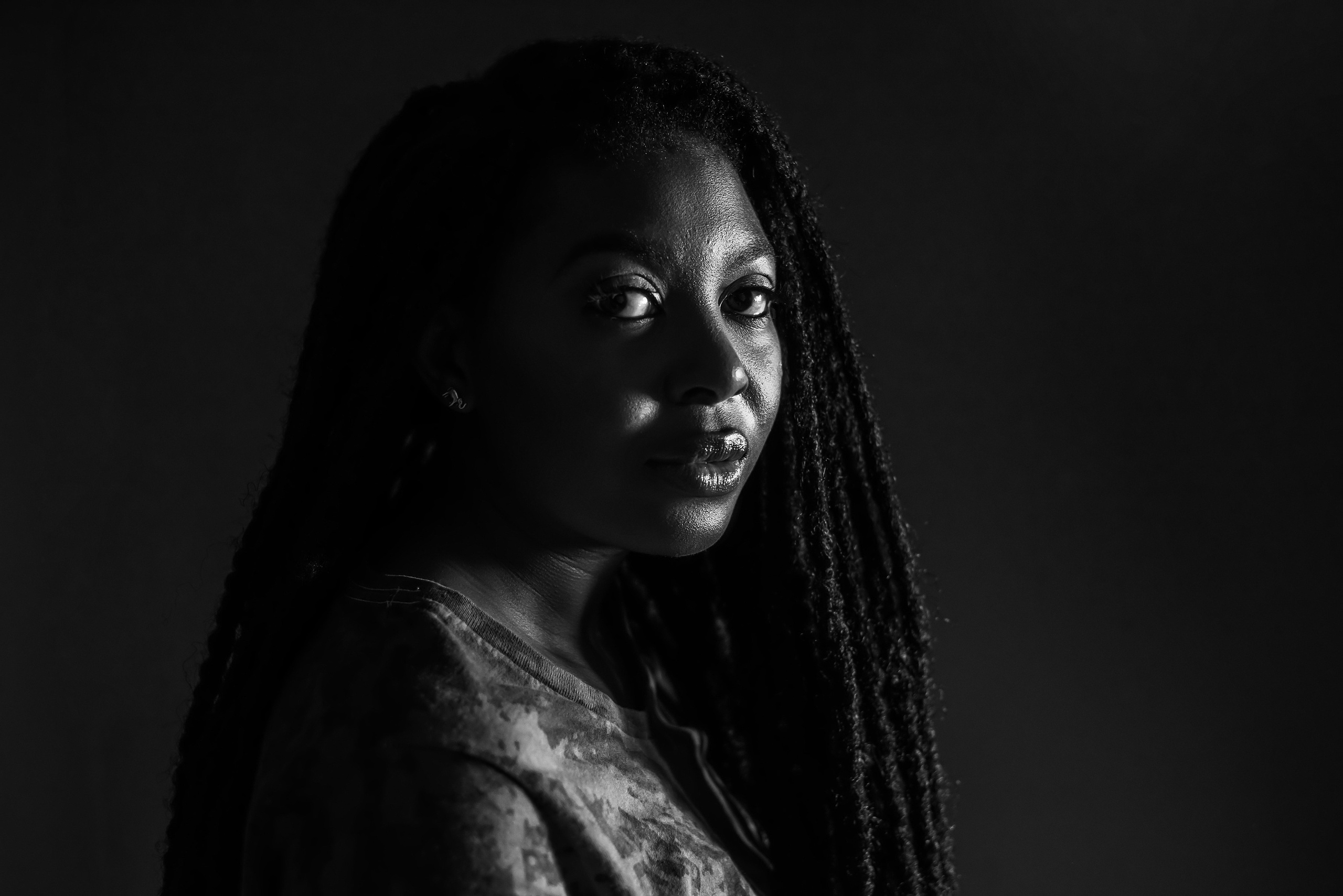 Black and white studio portrait of woman with braided hair — artistic portrait by Nick Ouma Photography