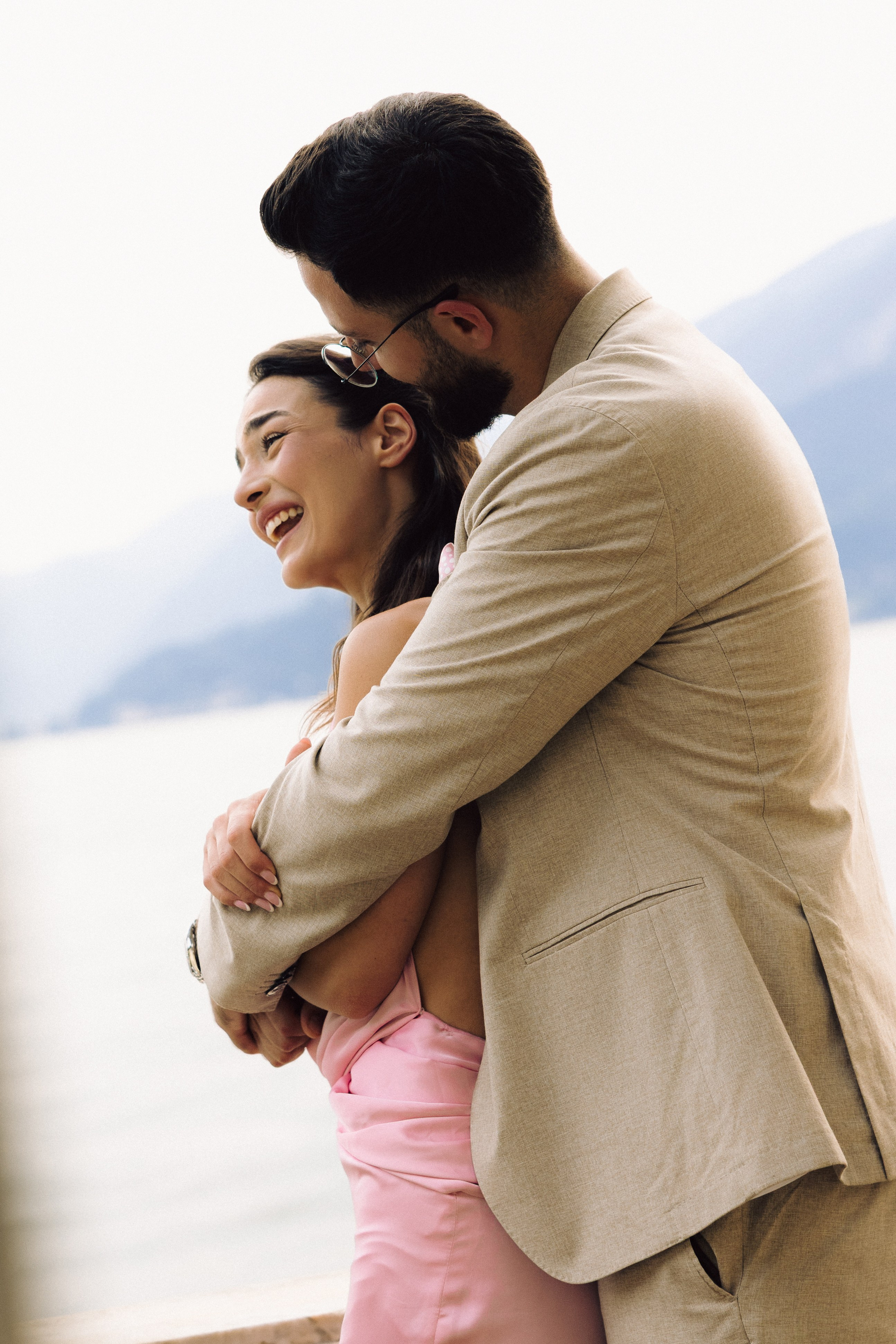 Newly engaged couple posing together with Lake Como