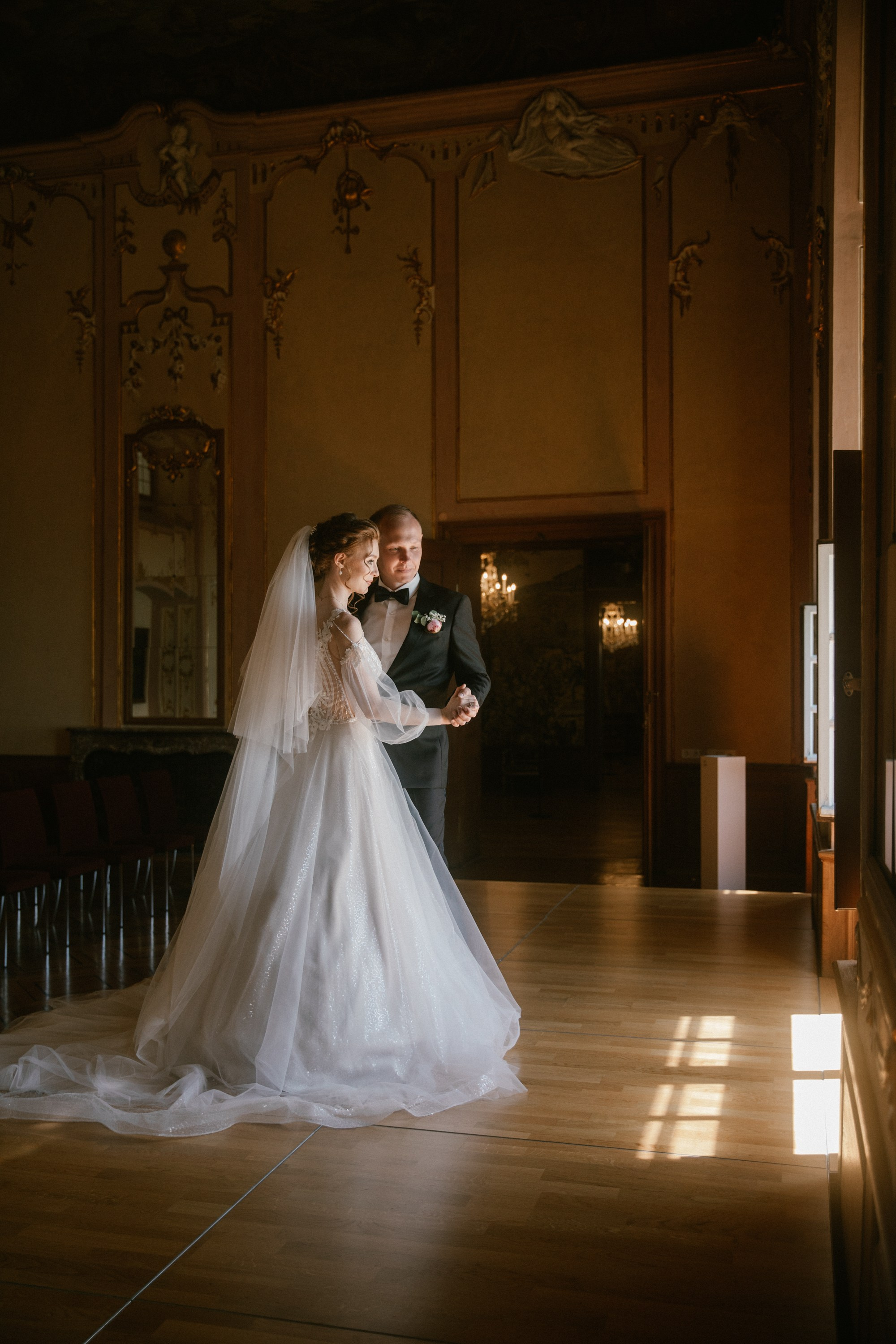 Brautpaar tanzt unter Kronleuchtern im Spiegelsaal – Hochzeit Schloss Meersburg