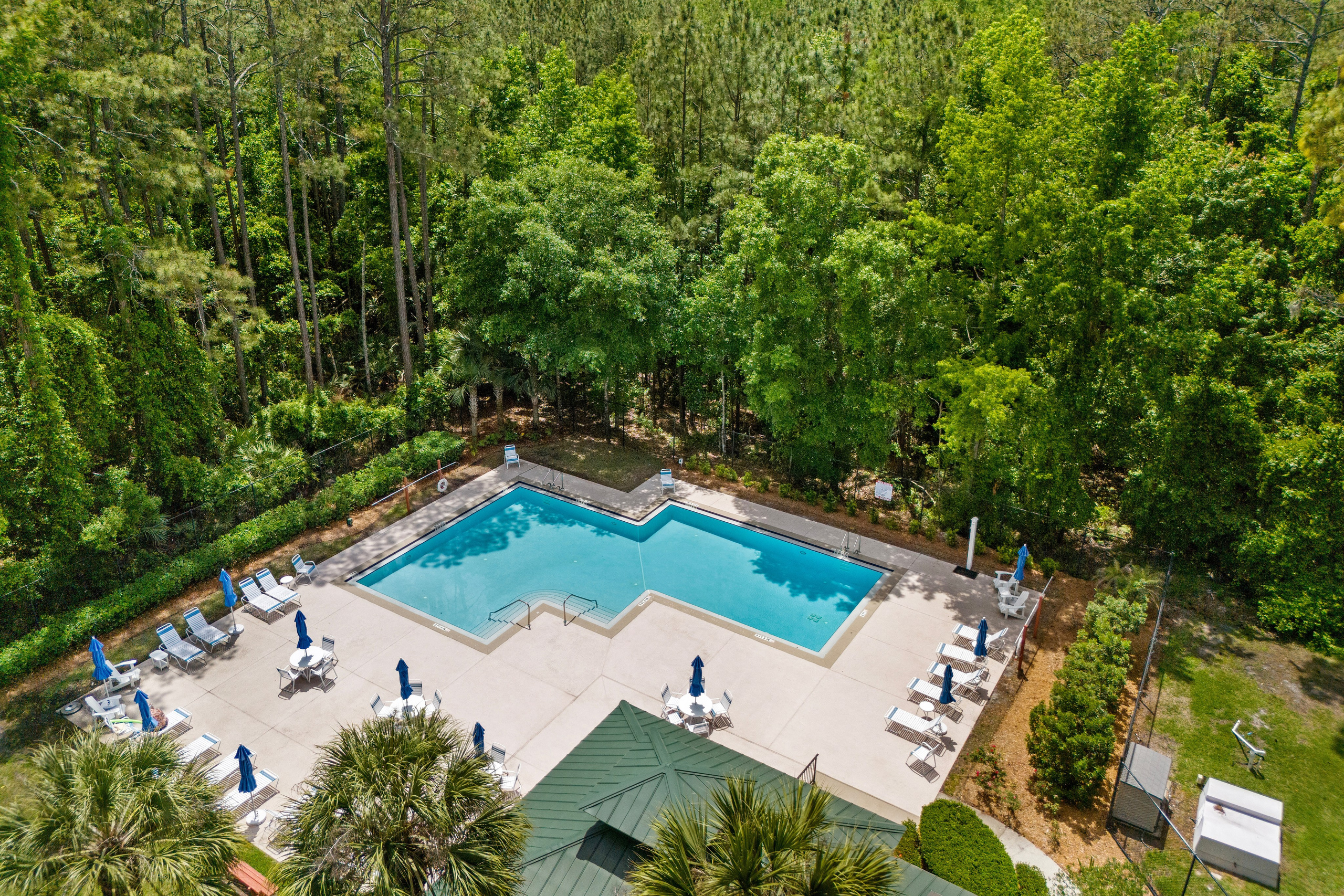 Peaceful outdoor pool surrounded by greenery and seating areas