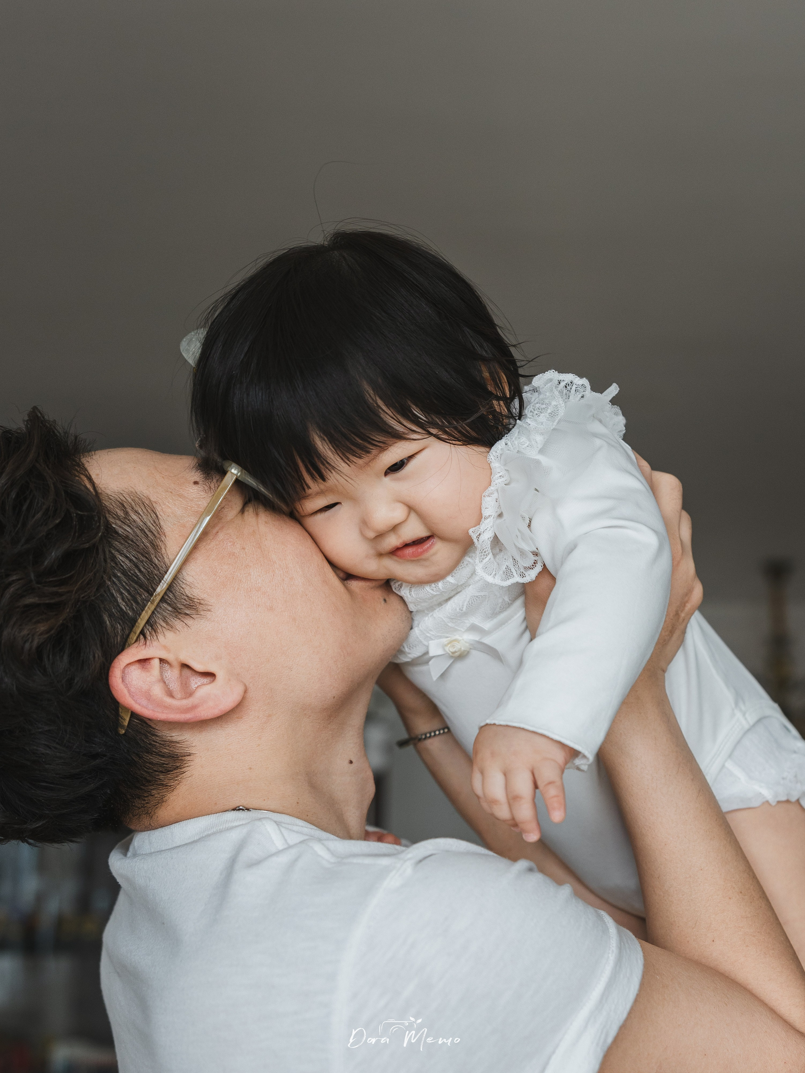 A tender moment as dad kisses his little girl.