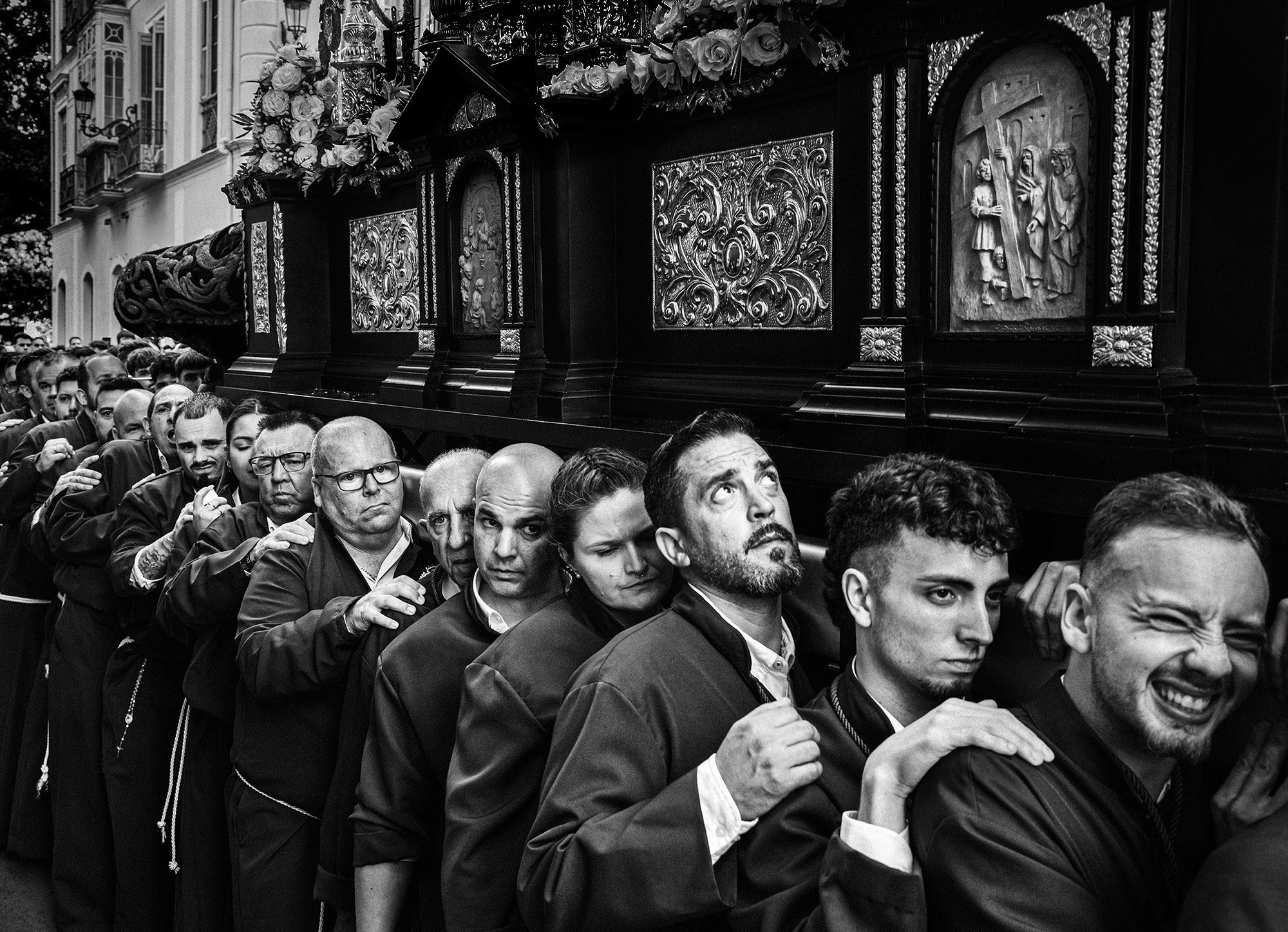 Costaleros carrying heavy paso during Semana Santa in Malaga