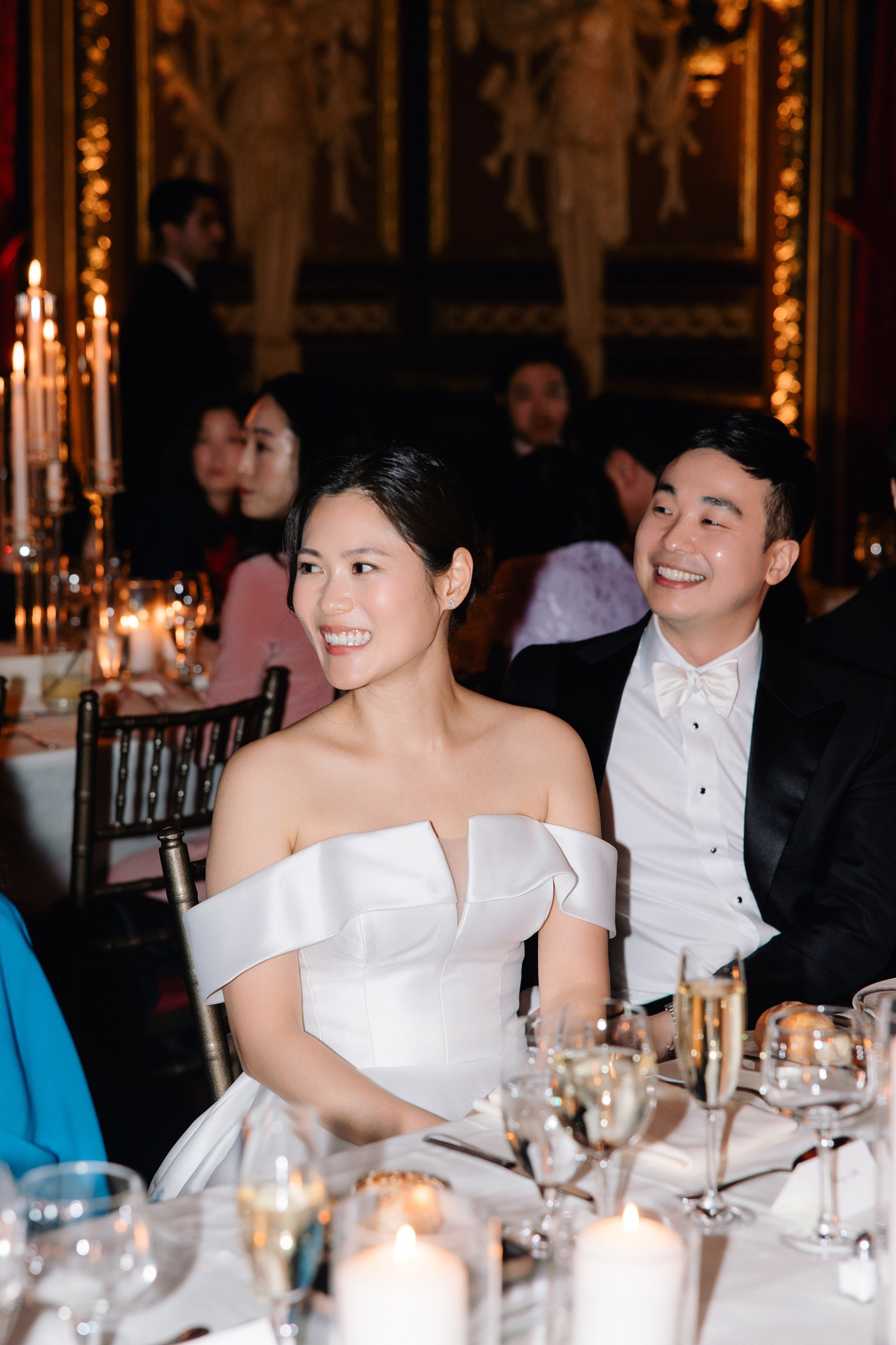 a couple sitting at a table with candles on it