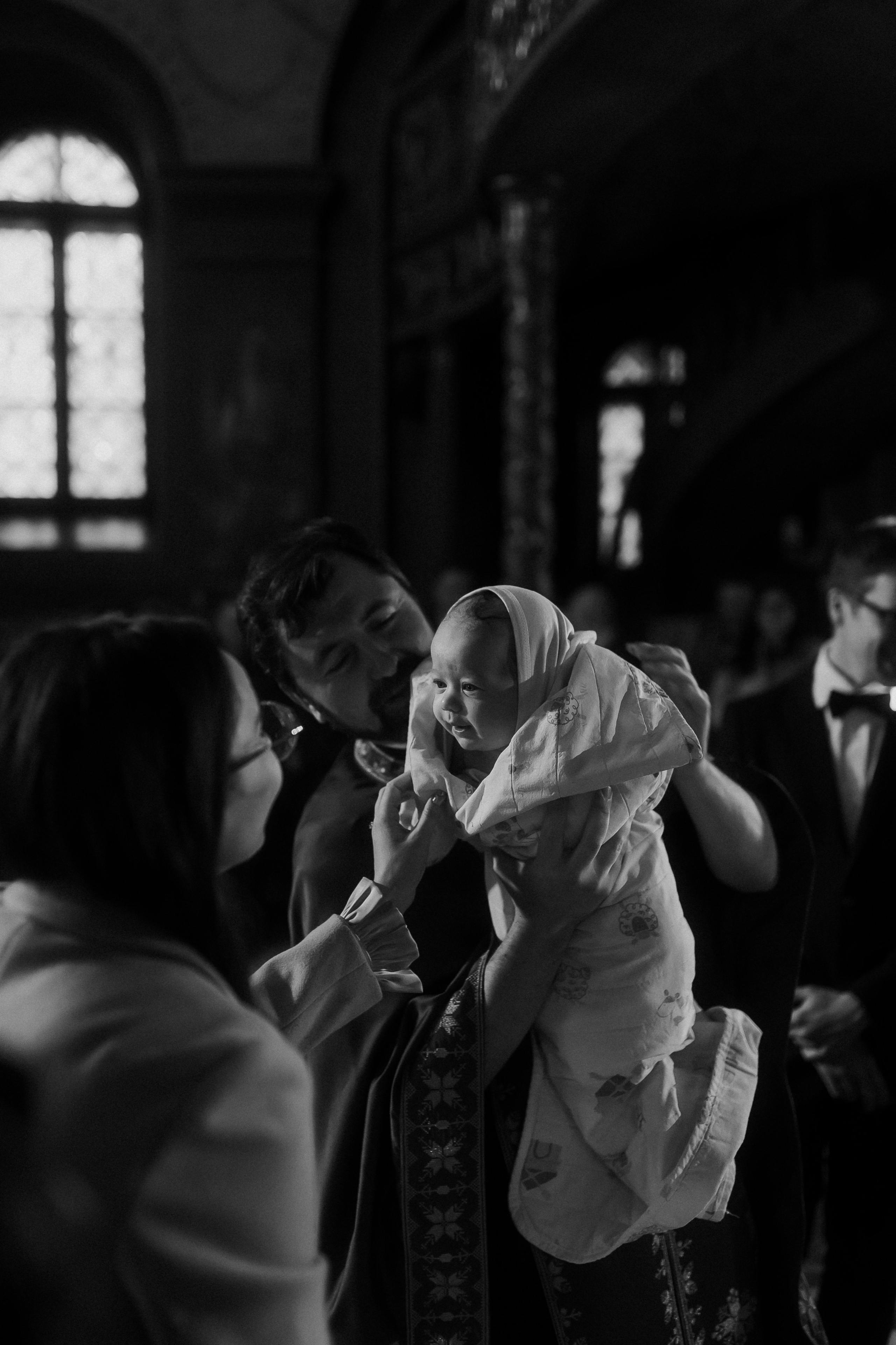 Botez în biserică, fotografiat cu atenție la detalii și lumină naturală pentru un album de neprețuit