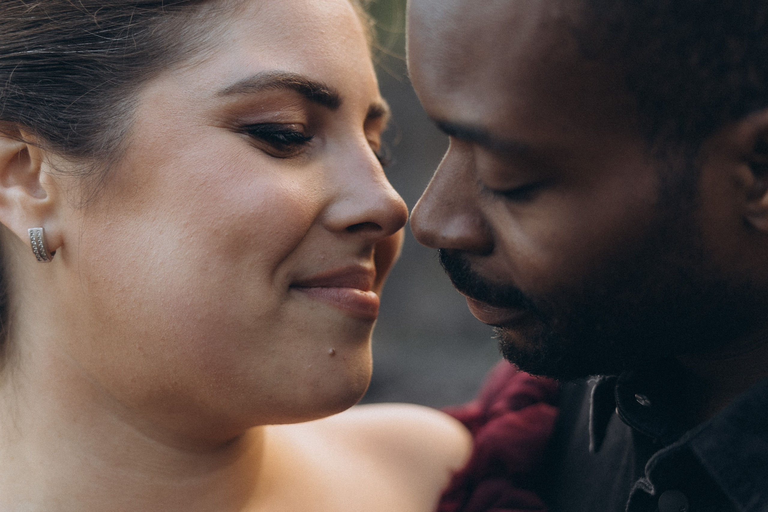 A glowing expectant mother standing on a cliff overlooking the ocean in Madeira, her dress flowing gently in the wind as the golden sunset casts a warm glow.