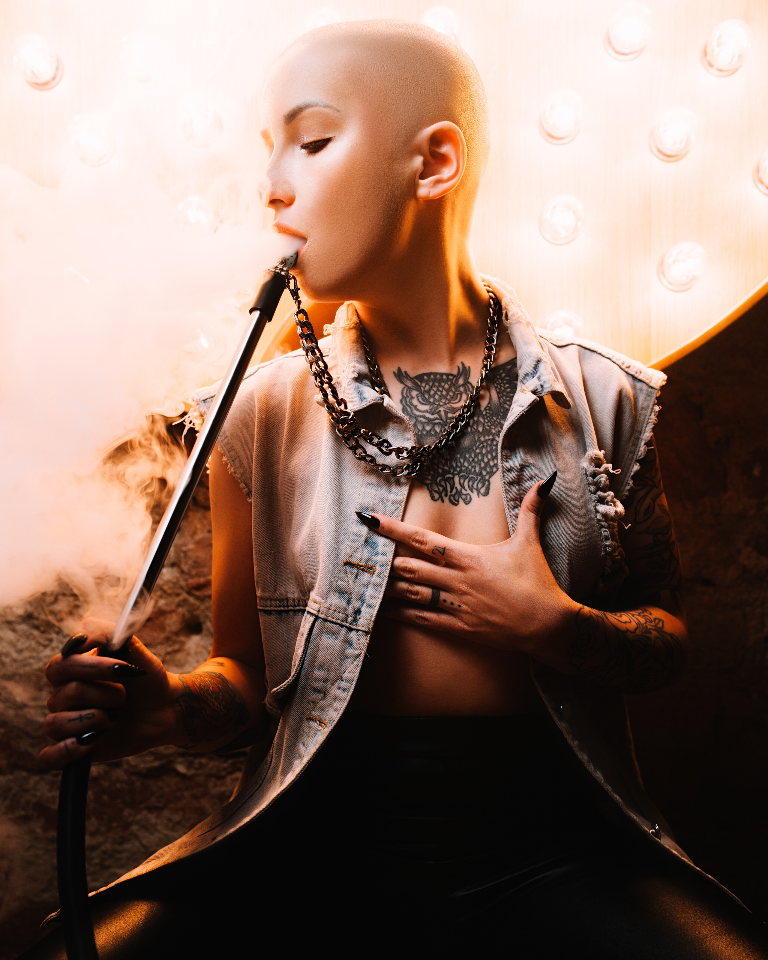 A close-up of a bald woman, with hookah, illuminated by dramatic lighting in a cinematic atmosphere, located in Hookahplace