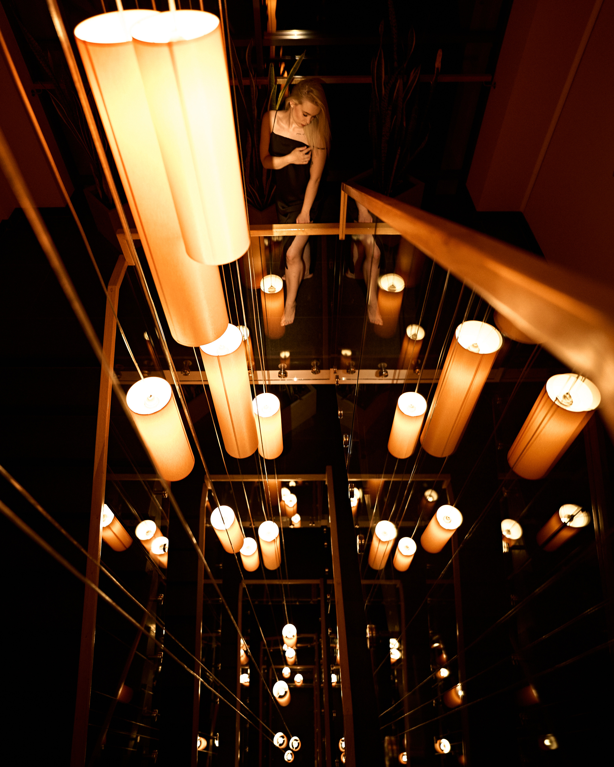 A warm, artistic shot of overhead lights in a modern interior, creating an abstract and dynamic composition.