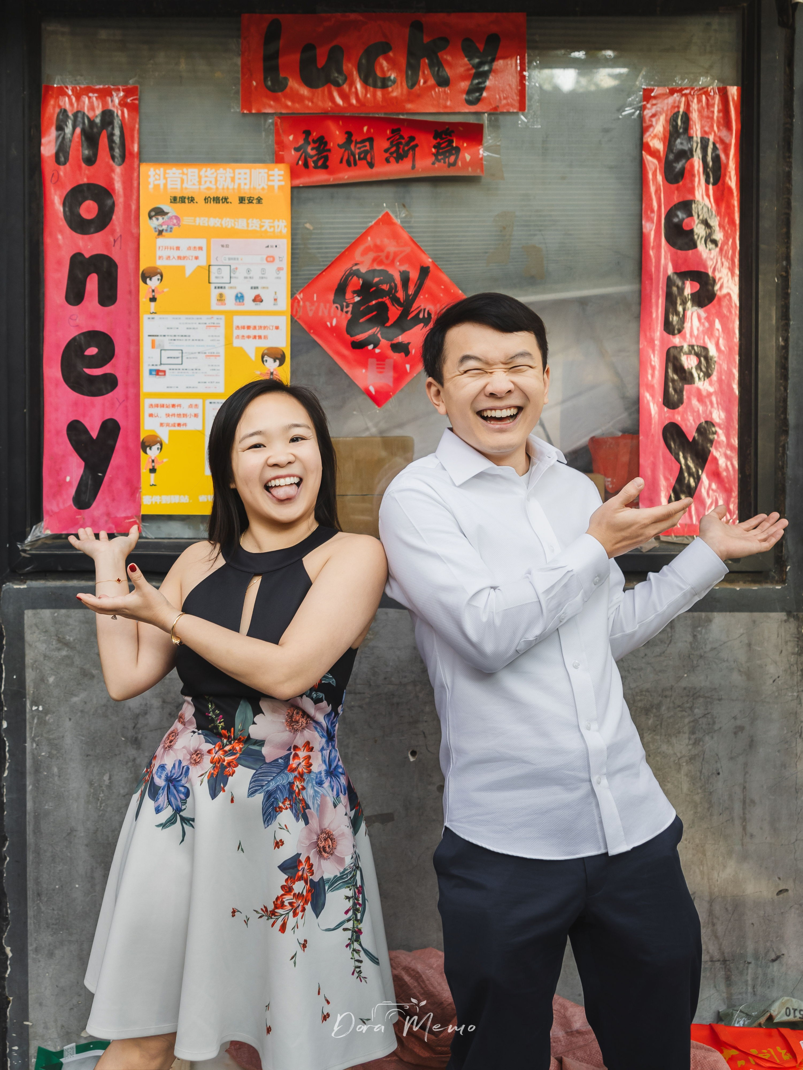 Couple standing back to back with arms spread, playful energy