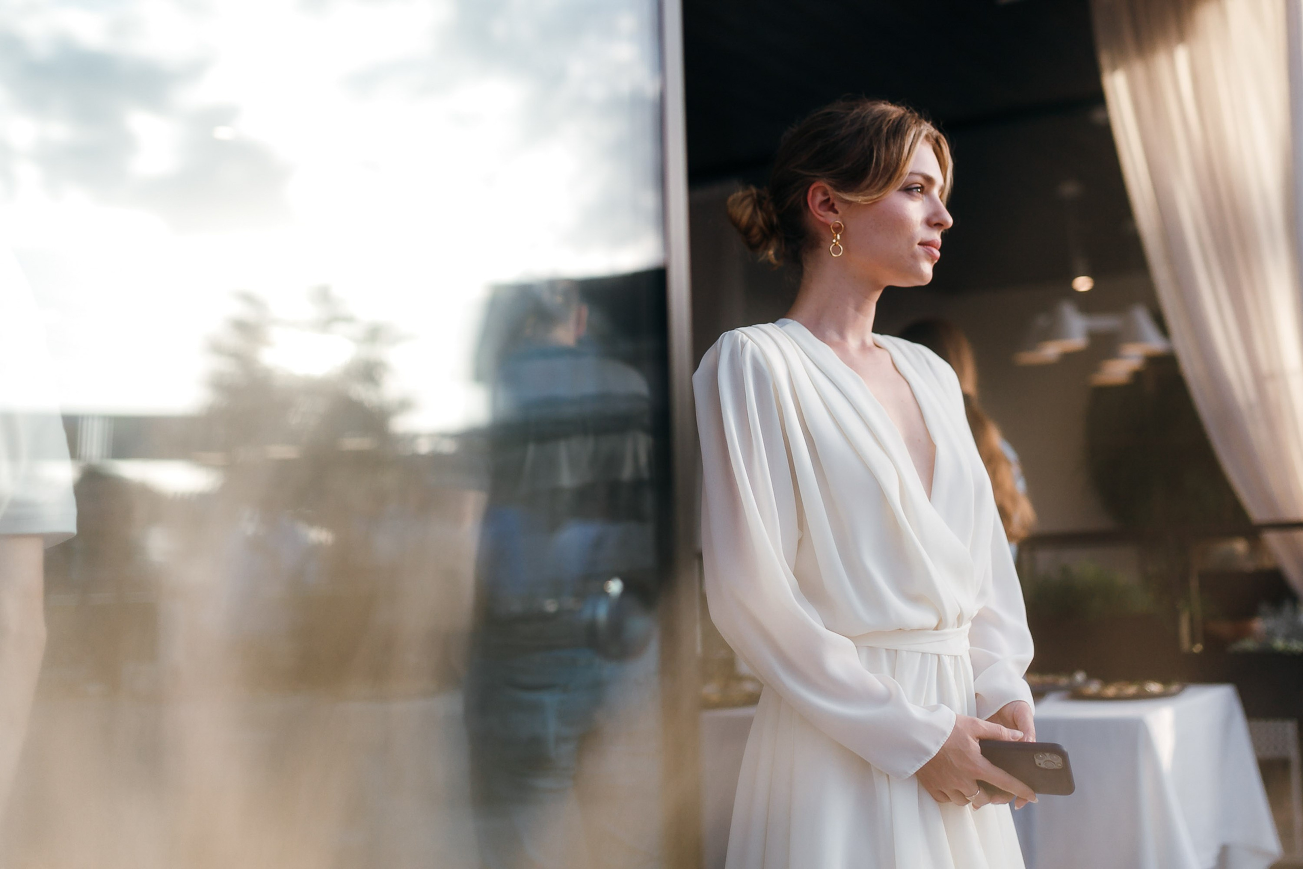 Woman in white shirt by window with soft light