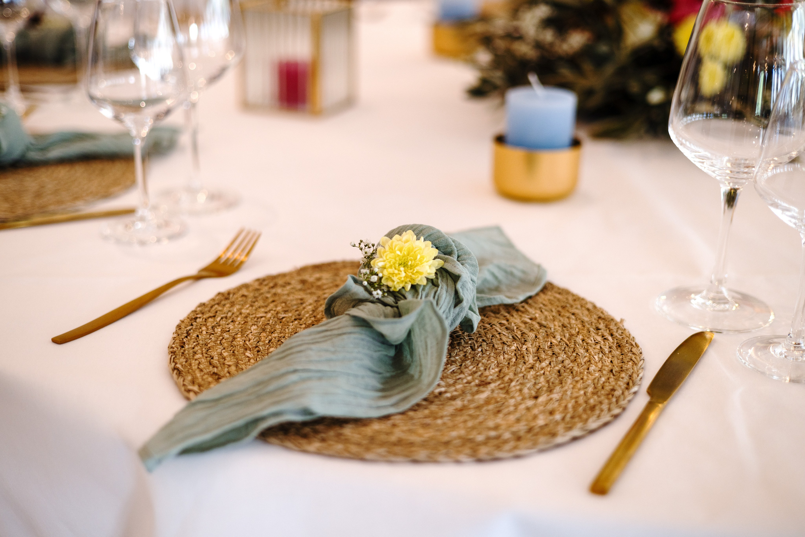 Elegante Tischdekoration mit weißen Blumen, Kerzen und goldenen Akzenten für eine romantische Hochzeitsfeier.