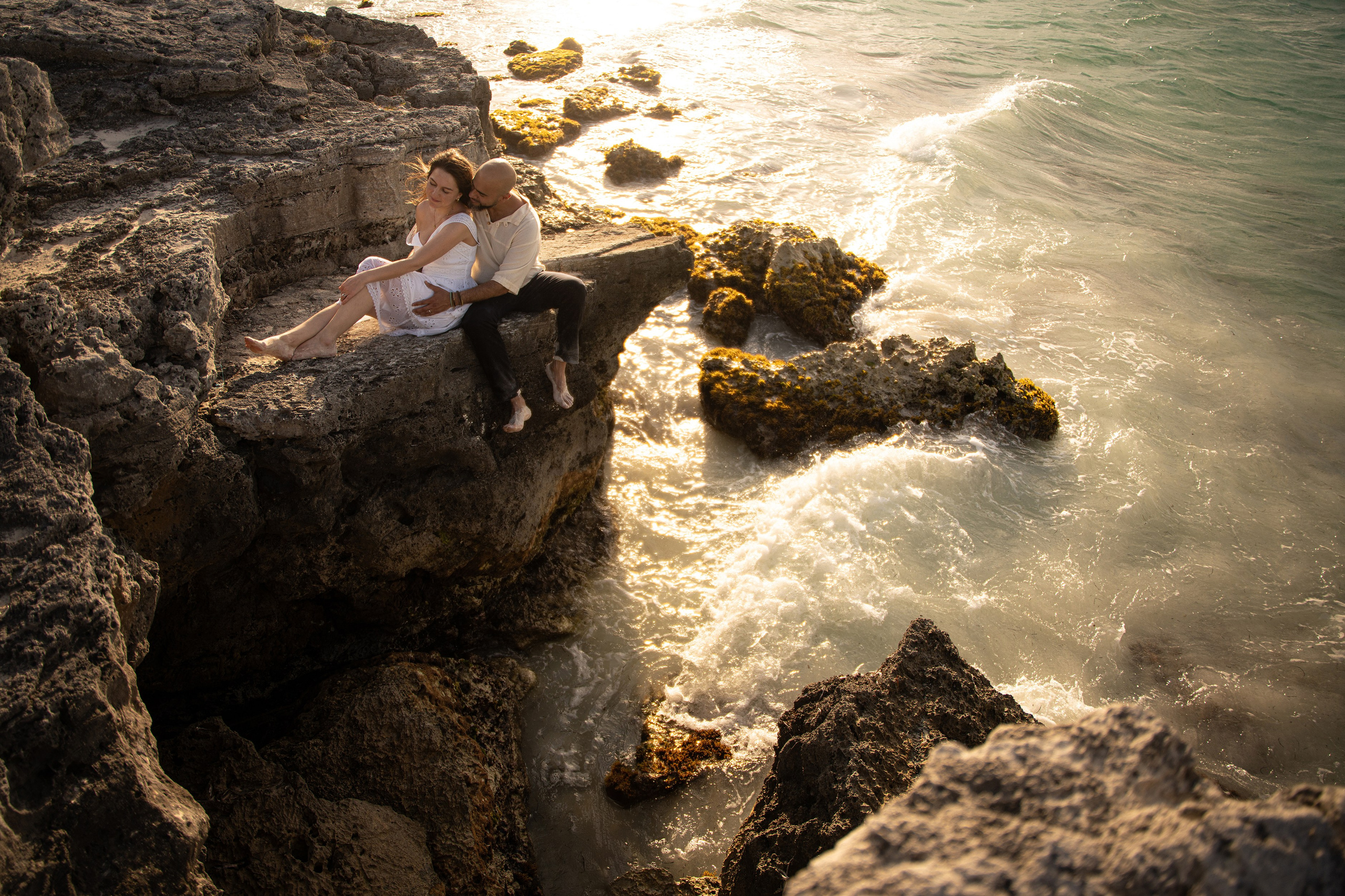 Couple posing on rocks in Playa del Carmen coastline