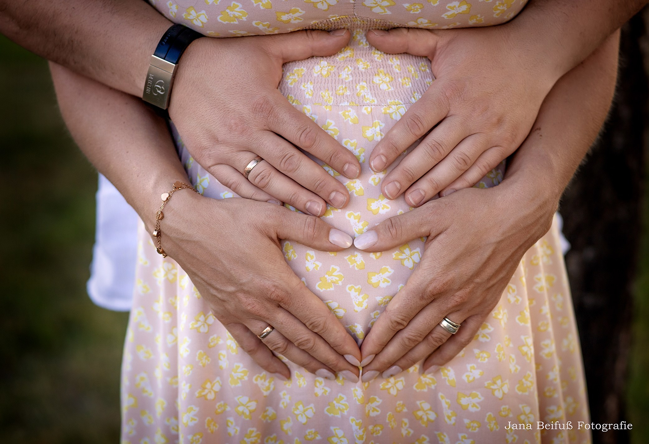 werdende Eltern haben die Hände am Babybauch und formen ein Herz mit den Händen - Schwangerschaftsfotograf Jana Beifuß in Weißenhorn bei Ulm