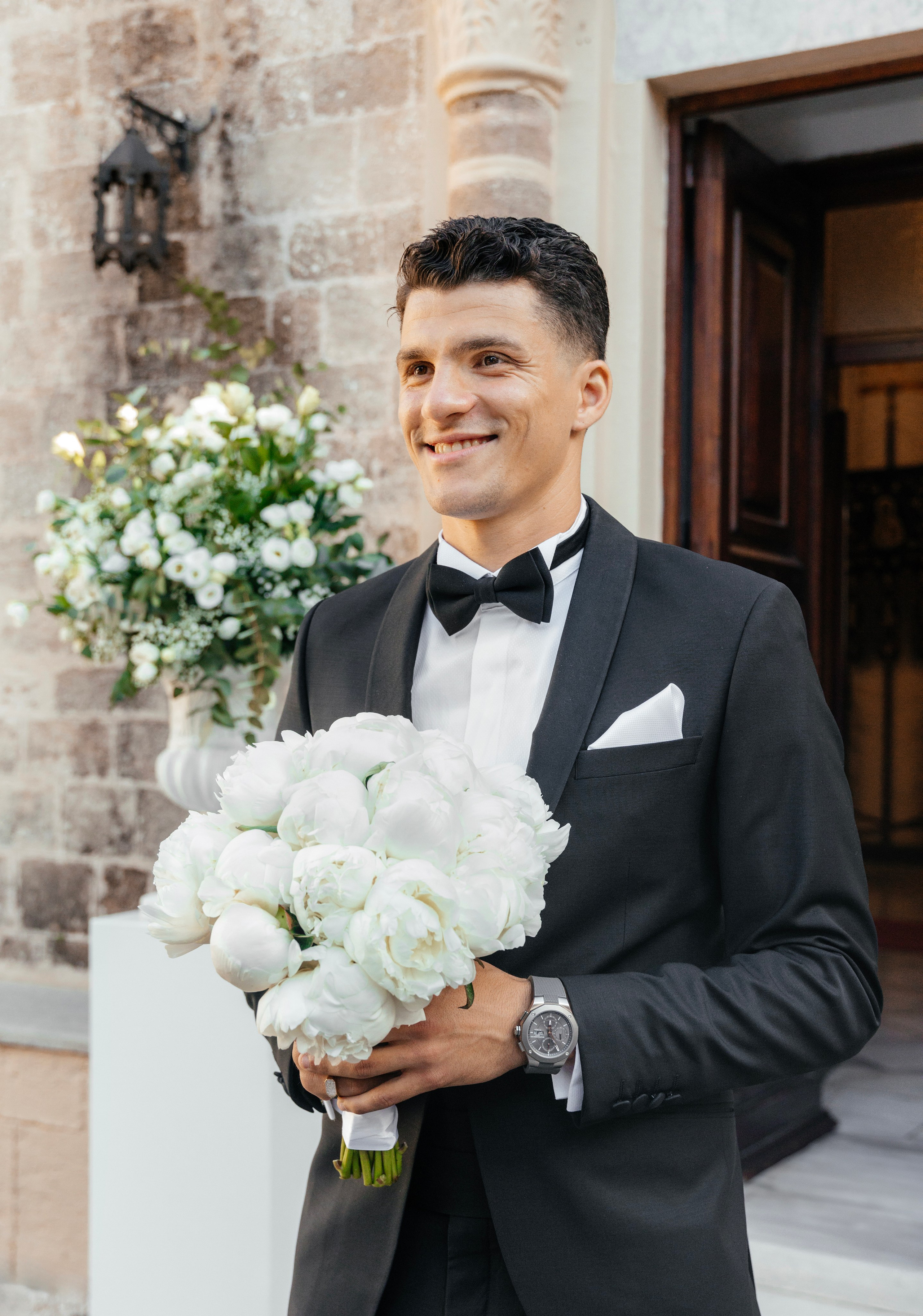 A groom is happy and waiting for the bride near the church.  Rhodes Greece