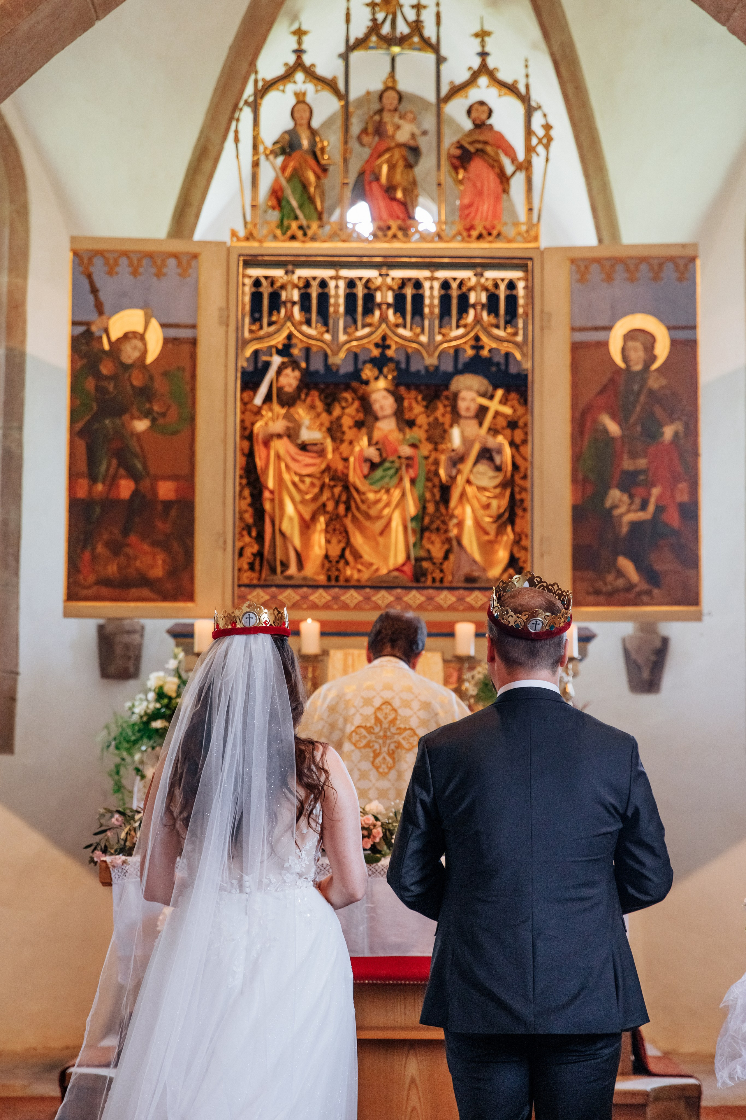 Das Brautpaar steht vor einem prächtigen Altar mit Ikonen während der Hochzeitszeremonie.