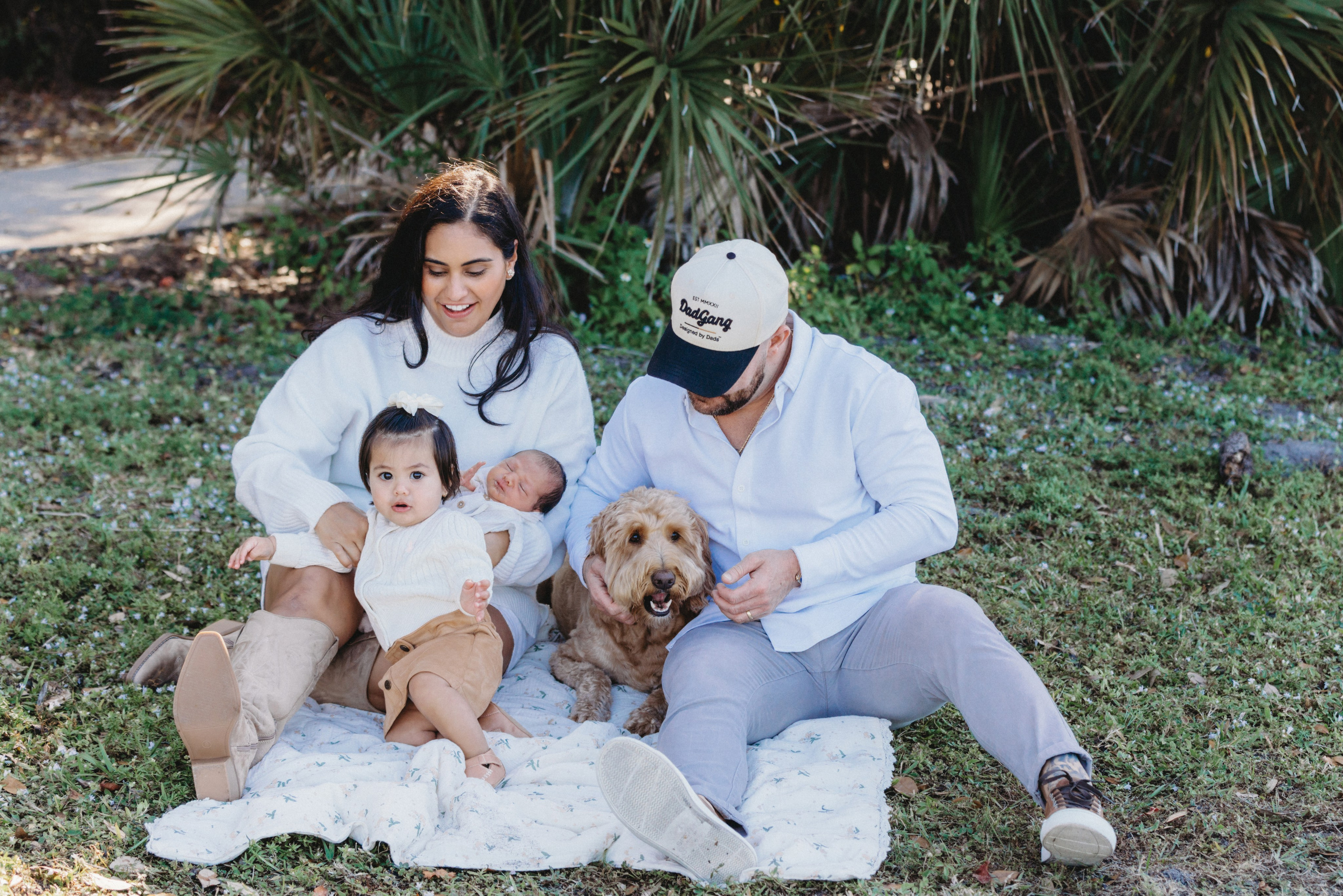  young family sitting on the blanket with the dog
