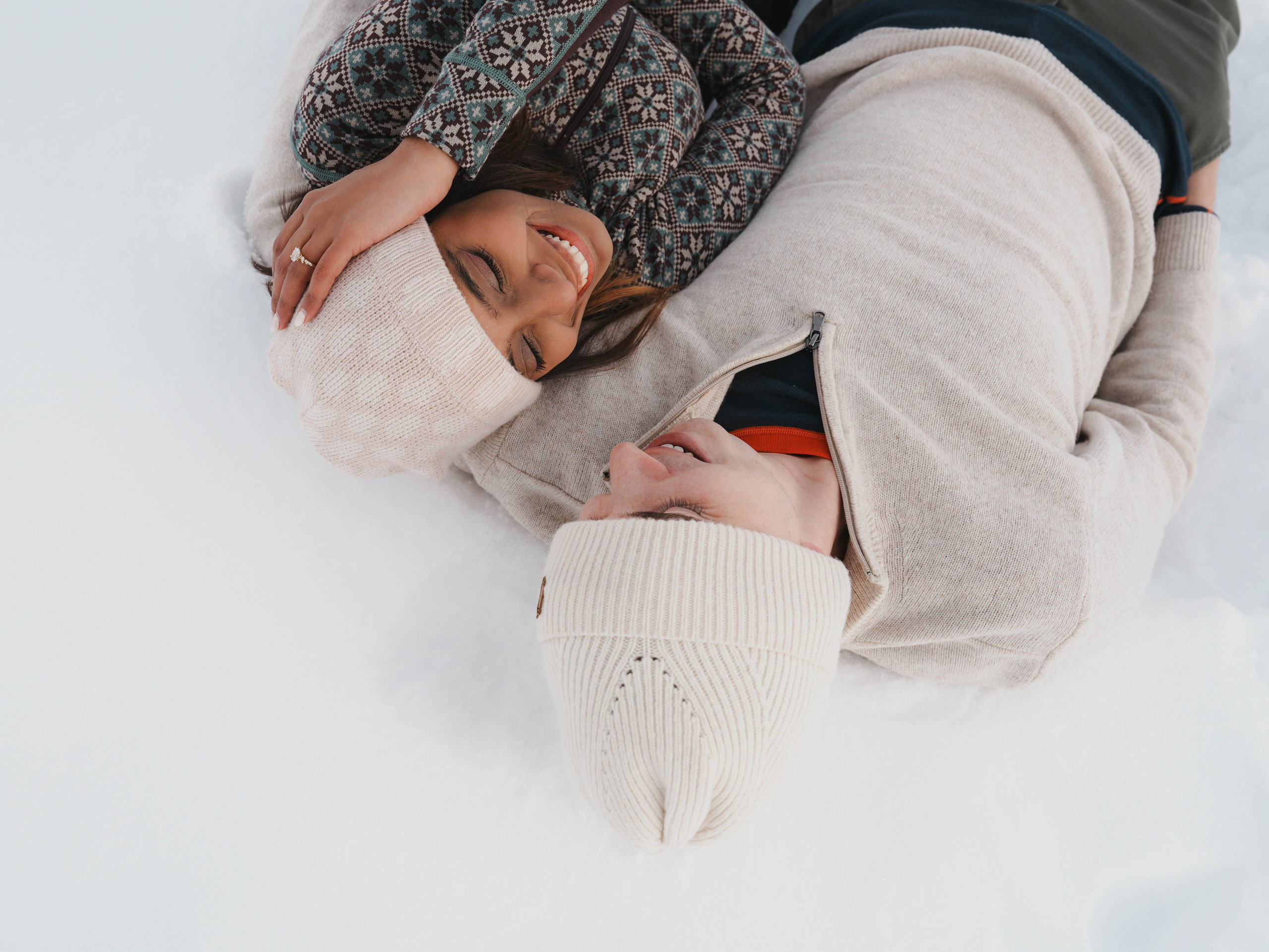 Couple lying in snow during winter photoshoot Georgia