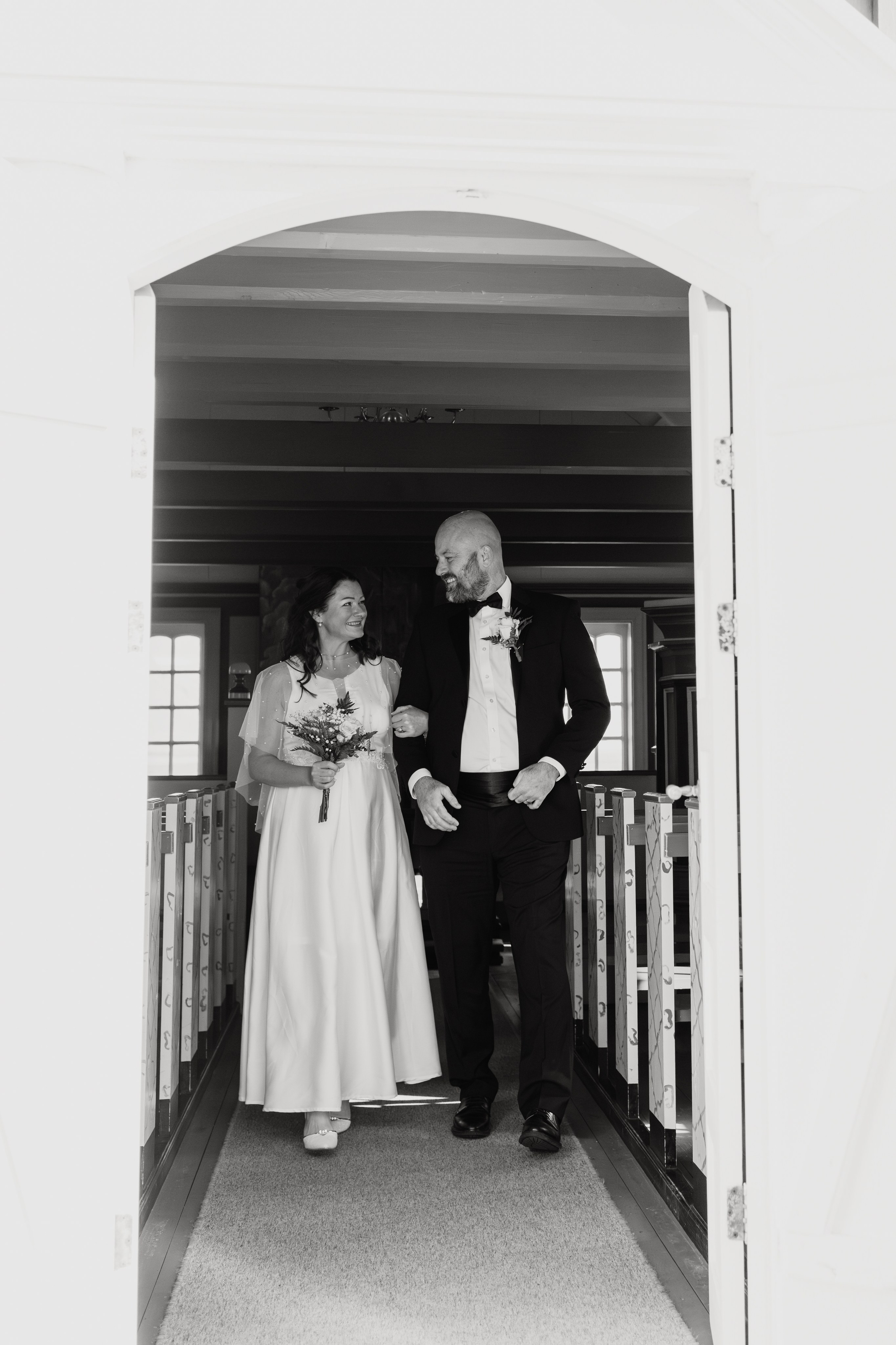 Candid moment of the wedding couple laughing near Búðir Church, surrounded by Iceland’s untamed nature.