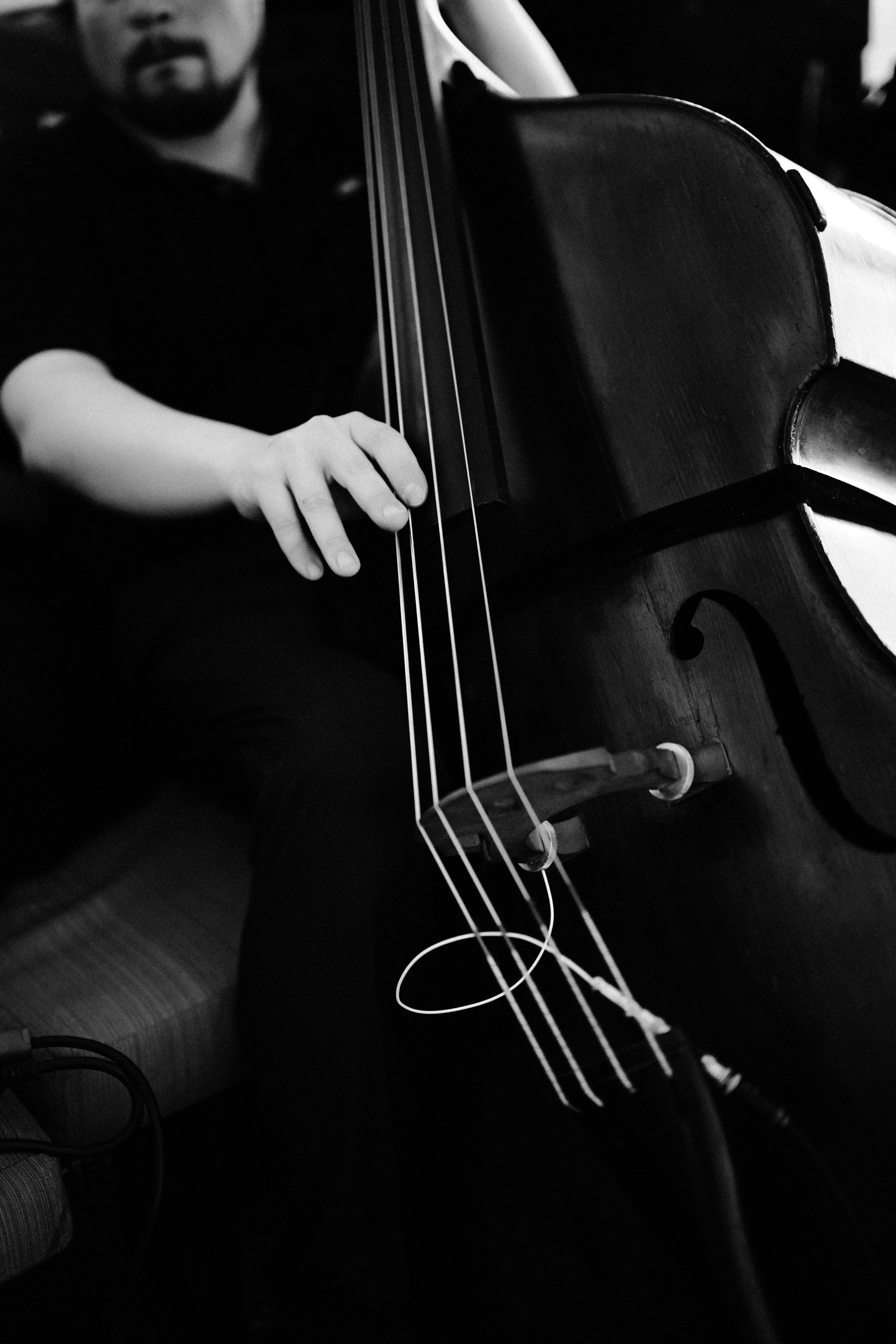a man sitting on a couch holding a cello