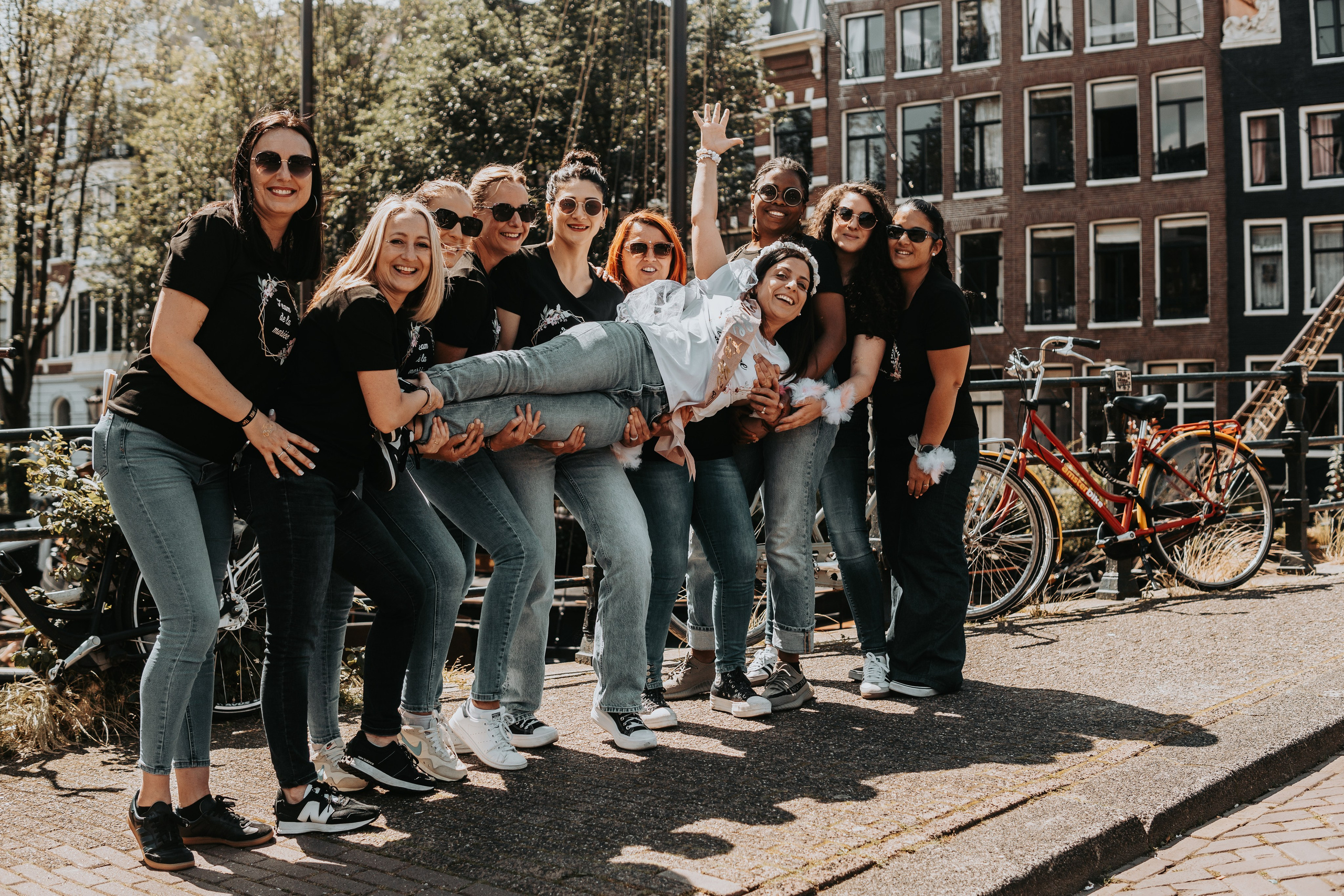 girls lifting the bride to be and holding her horizontally