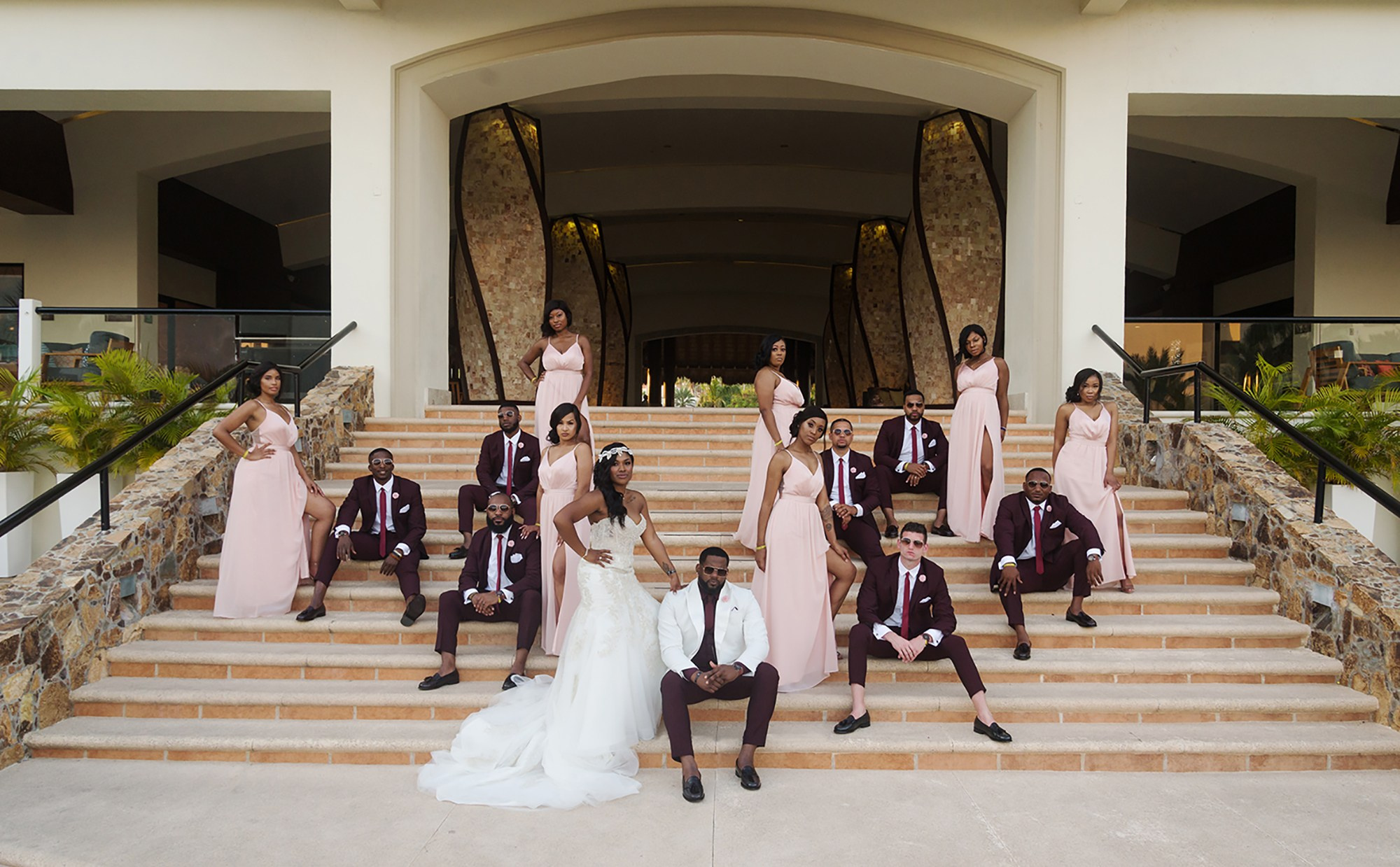 Wedding party portrait at Hyatt Ziva Los Cabos – bride and groom with bridesmaids and groomsmen in lobby staircase