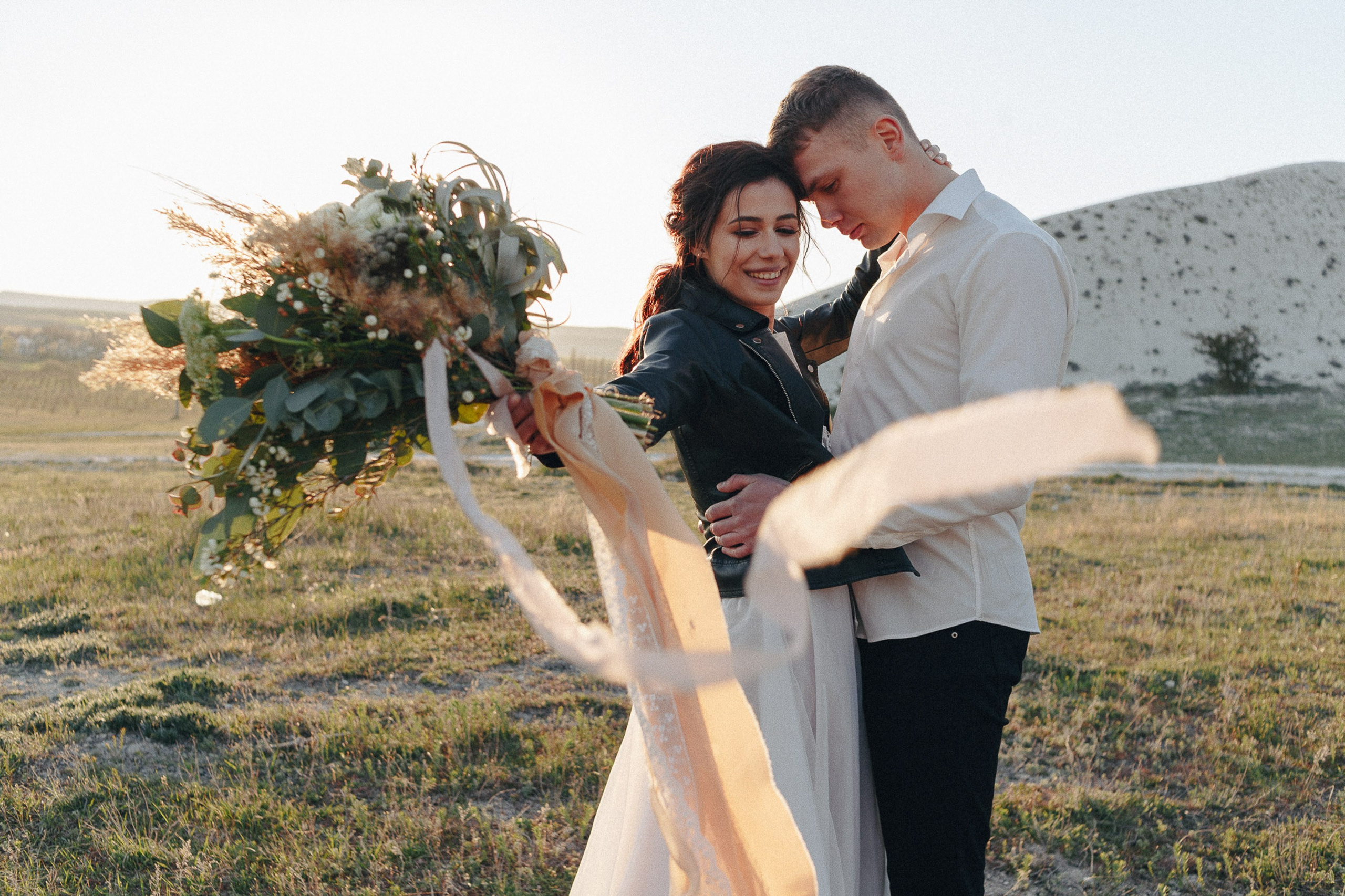 Bride and groom kissing outdoors in nature, romantic moment