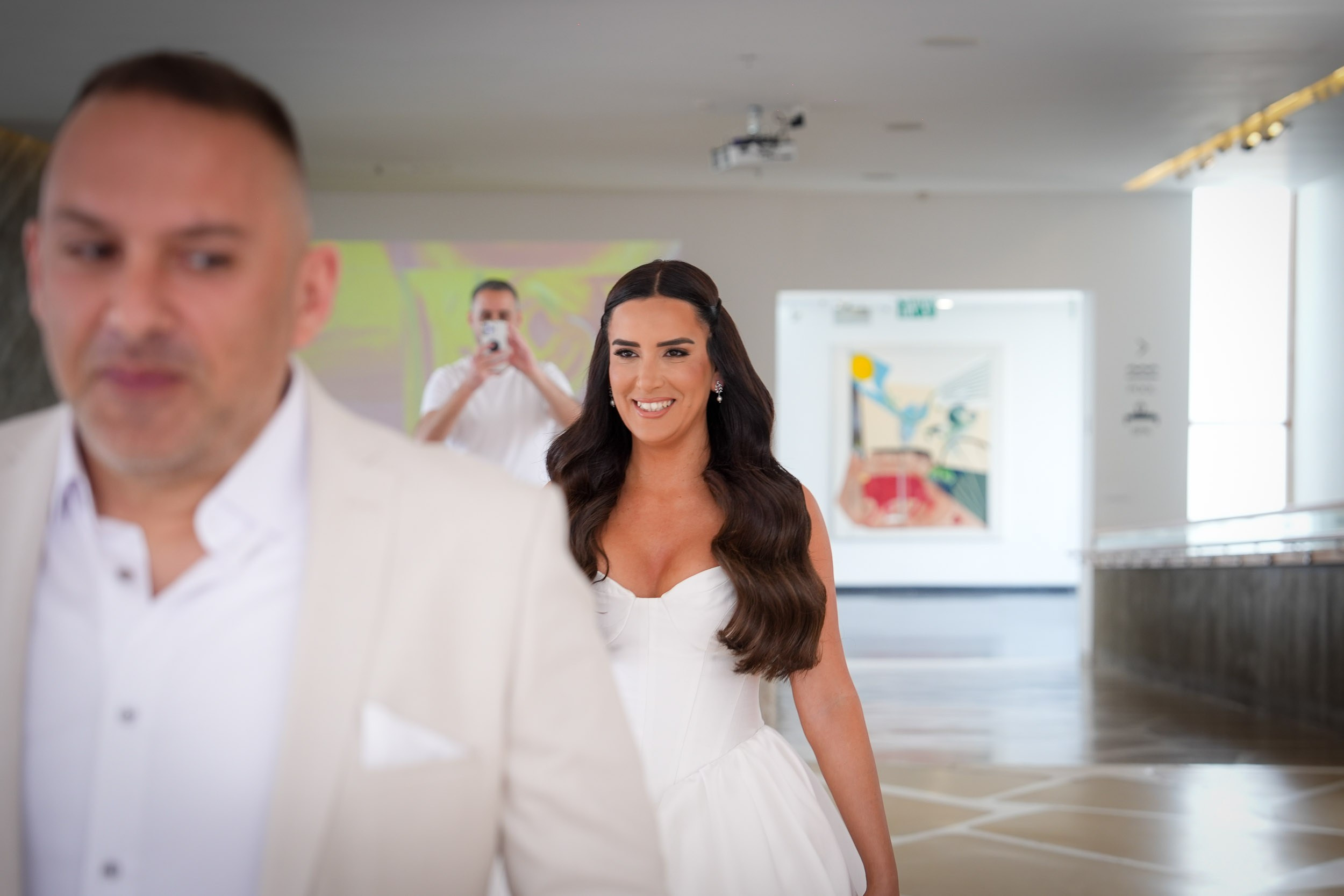 Bride Shani smiling and walking towards groom David during their emotional first look session in Zikhron Ya'akov, Israel