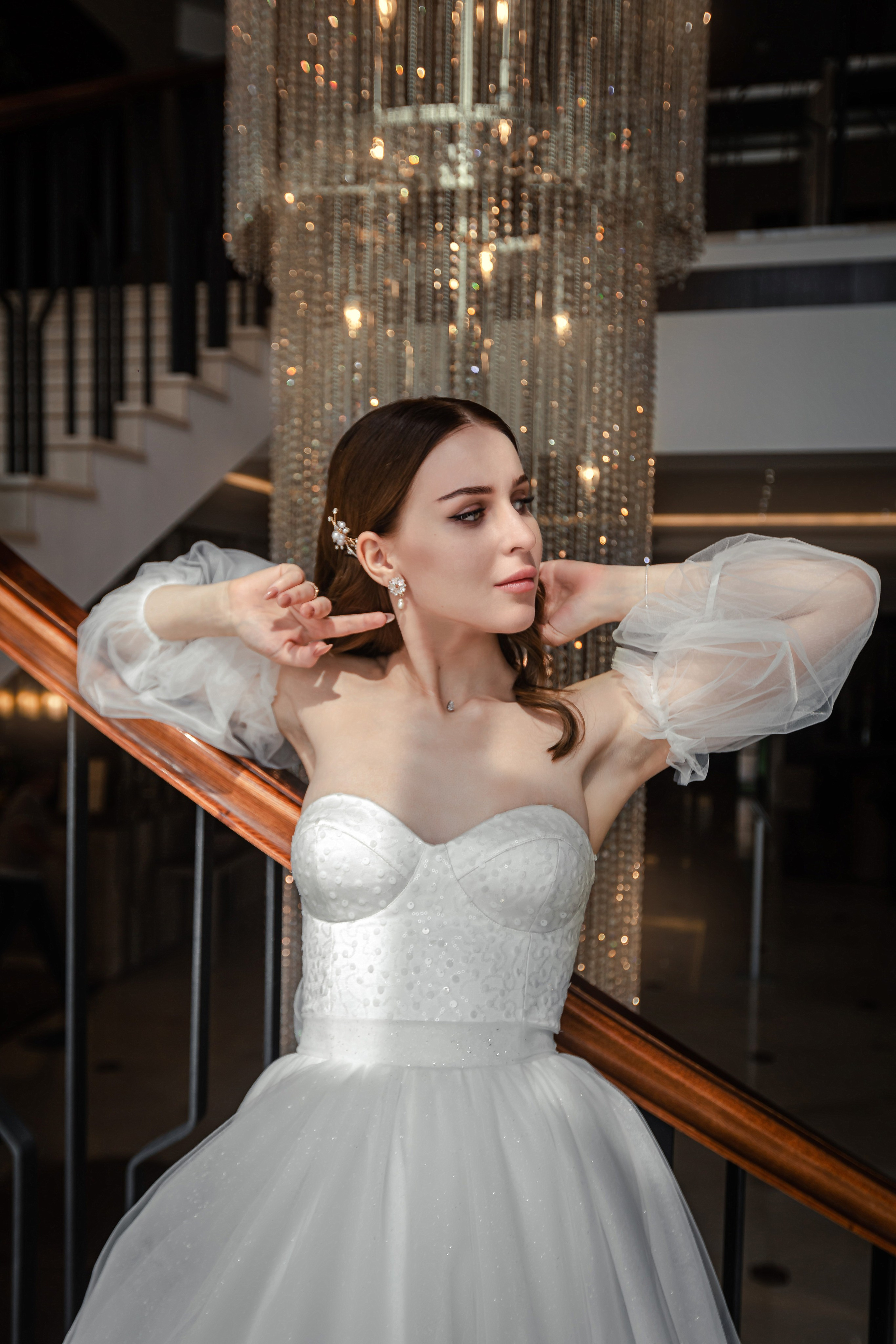 Novia con un hermoso vestido en las escaleras de un hotel caro en Valencia