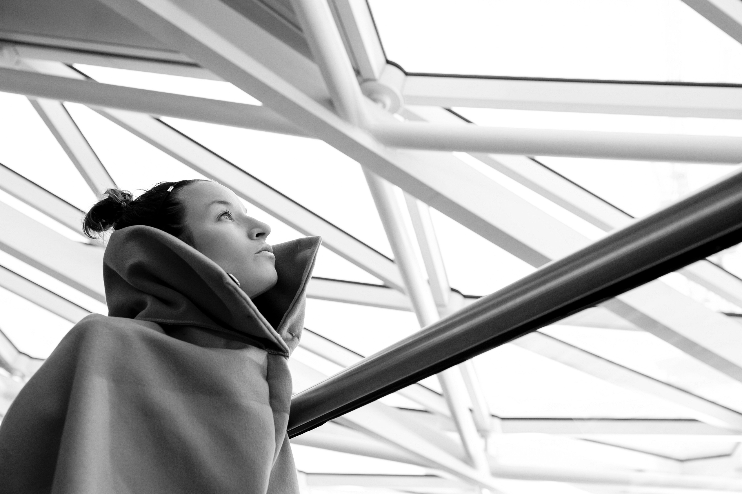Portrait of a woman looking through the transparent roof at King's Cross Station.