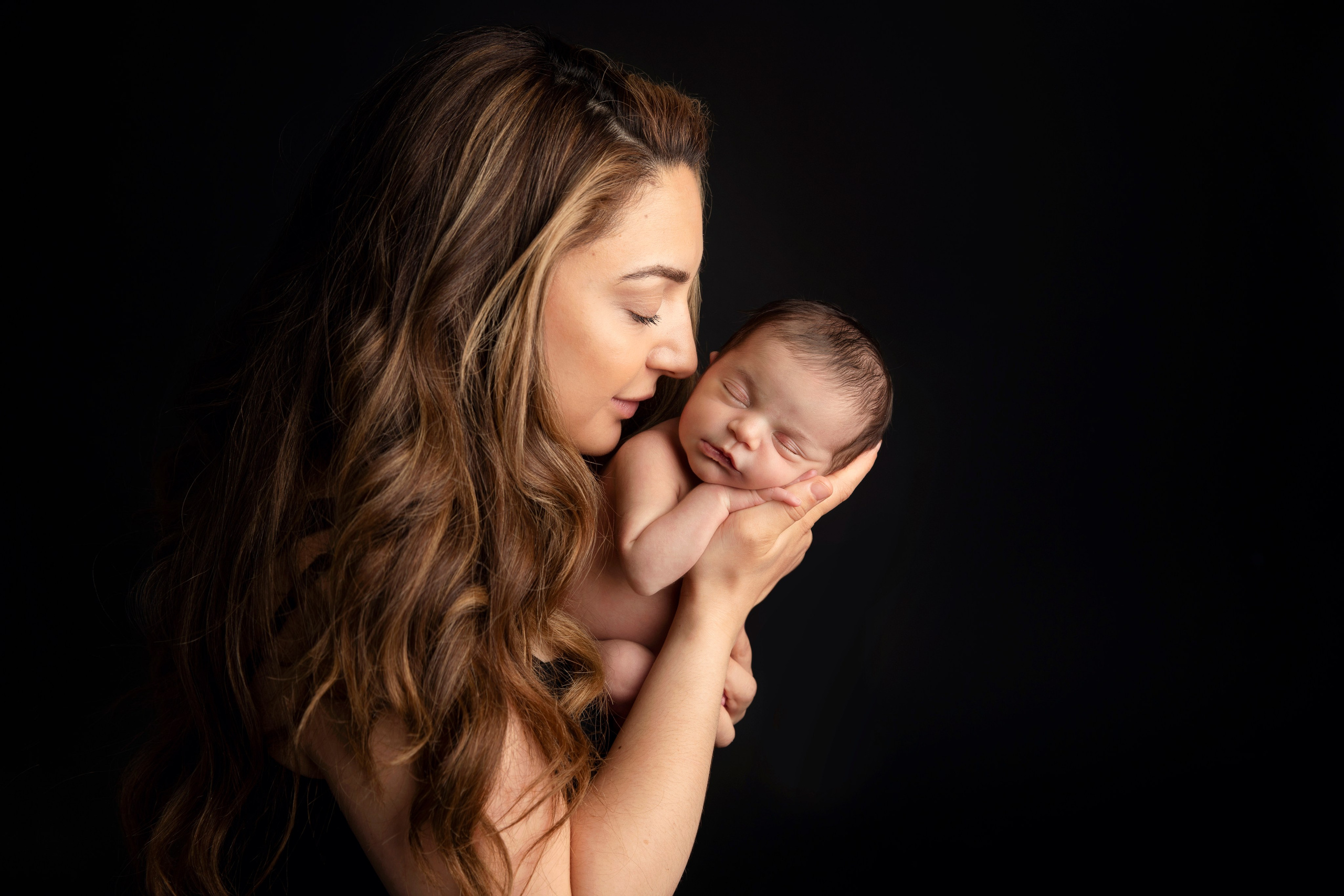 Pappa håller sin nyfödda bebis i famnen, ett fotografi av kärlek och stolthet.Storebror kramar sin lilla syster ömt, ett minnesvärt fotografi för livet tillsammans.