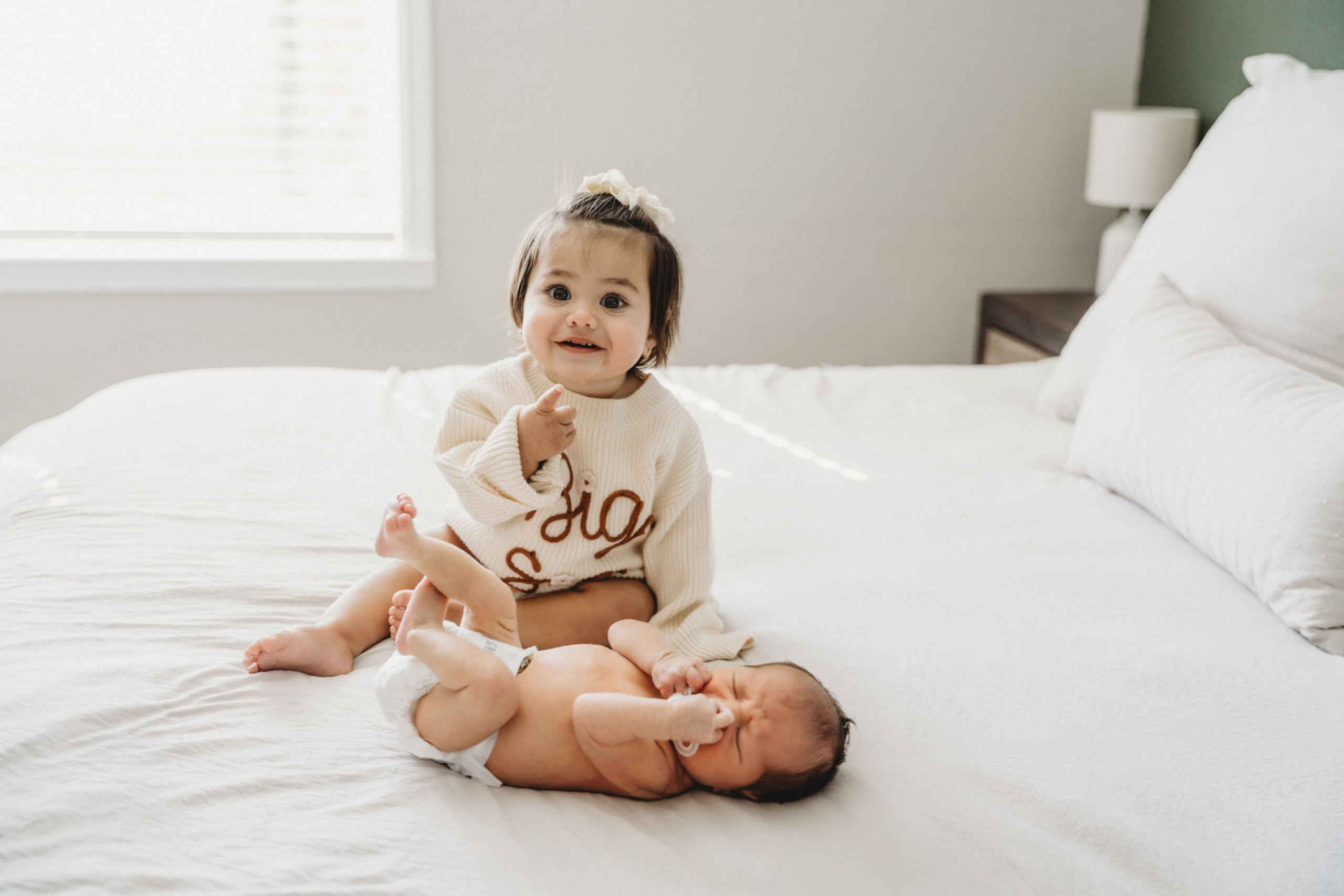 Photo of little girl and baby on the bed