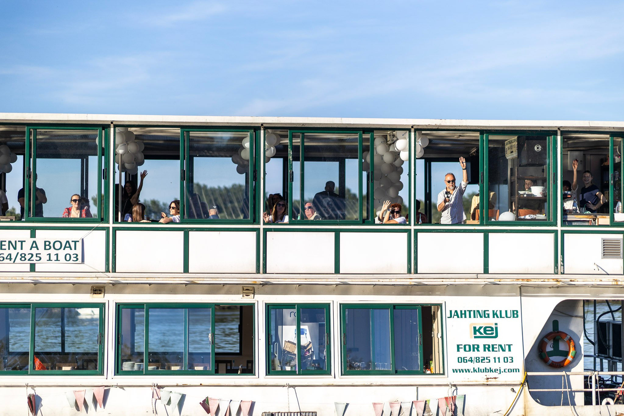 Deo turistickog recnog broda sa ljudima koji masu.