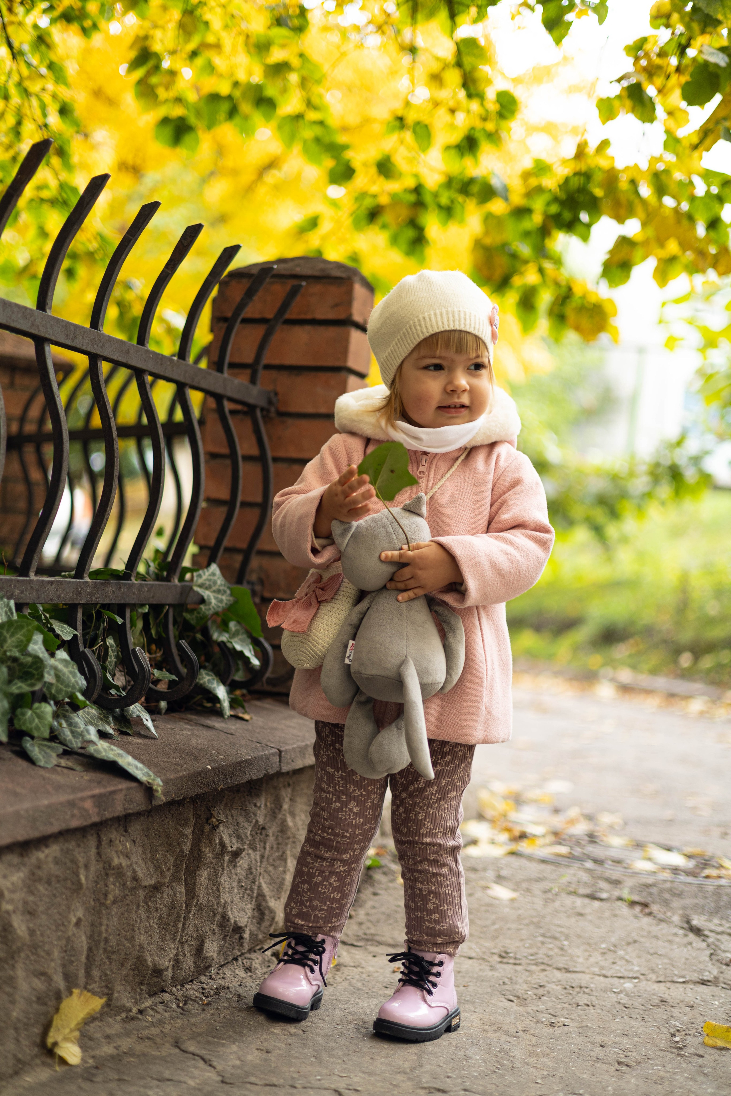 Девочка осенью с мягкой игрушкой.