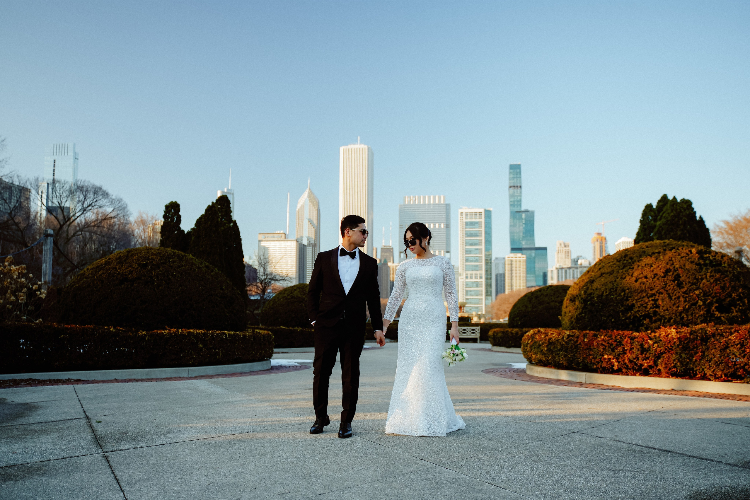 Bride and groom wedding portrait at Millennium Park Chicago with downtown skyline view and romantic city atmosphere.