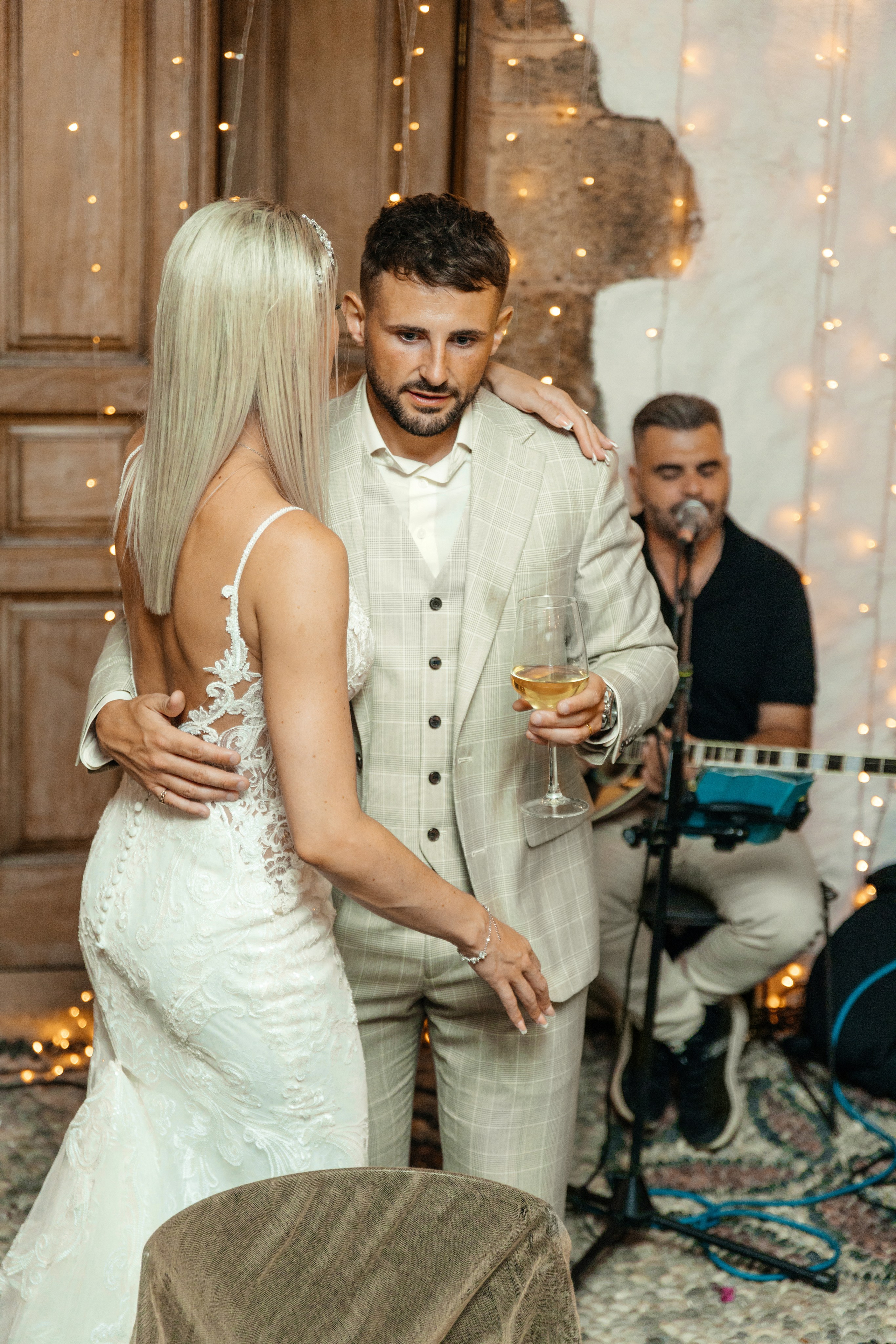Bride and groom are talking after a touching speech by a family member at their wedding reception in Lindos, Greece