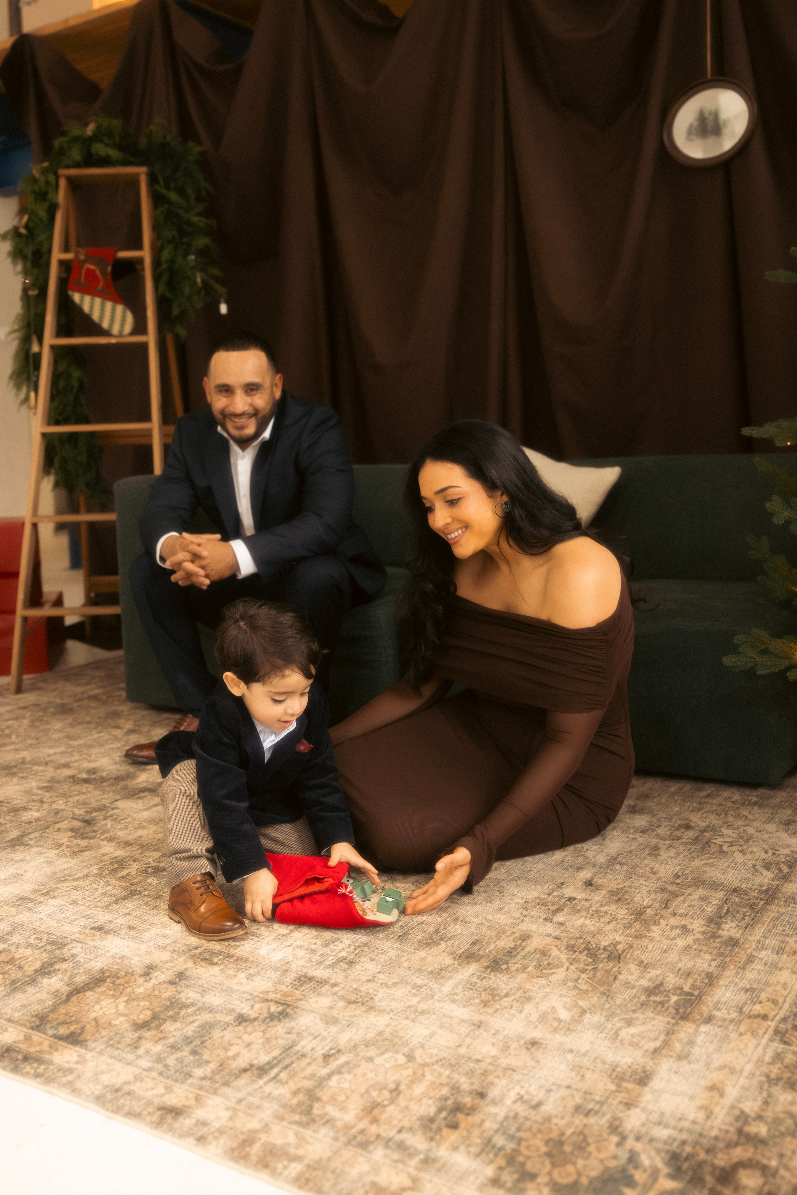 Mom holding baby near Christmas tree during holiday photo session
