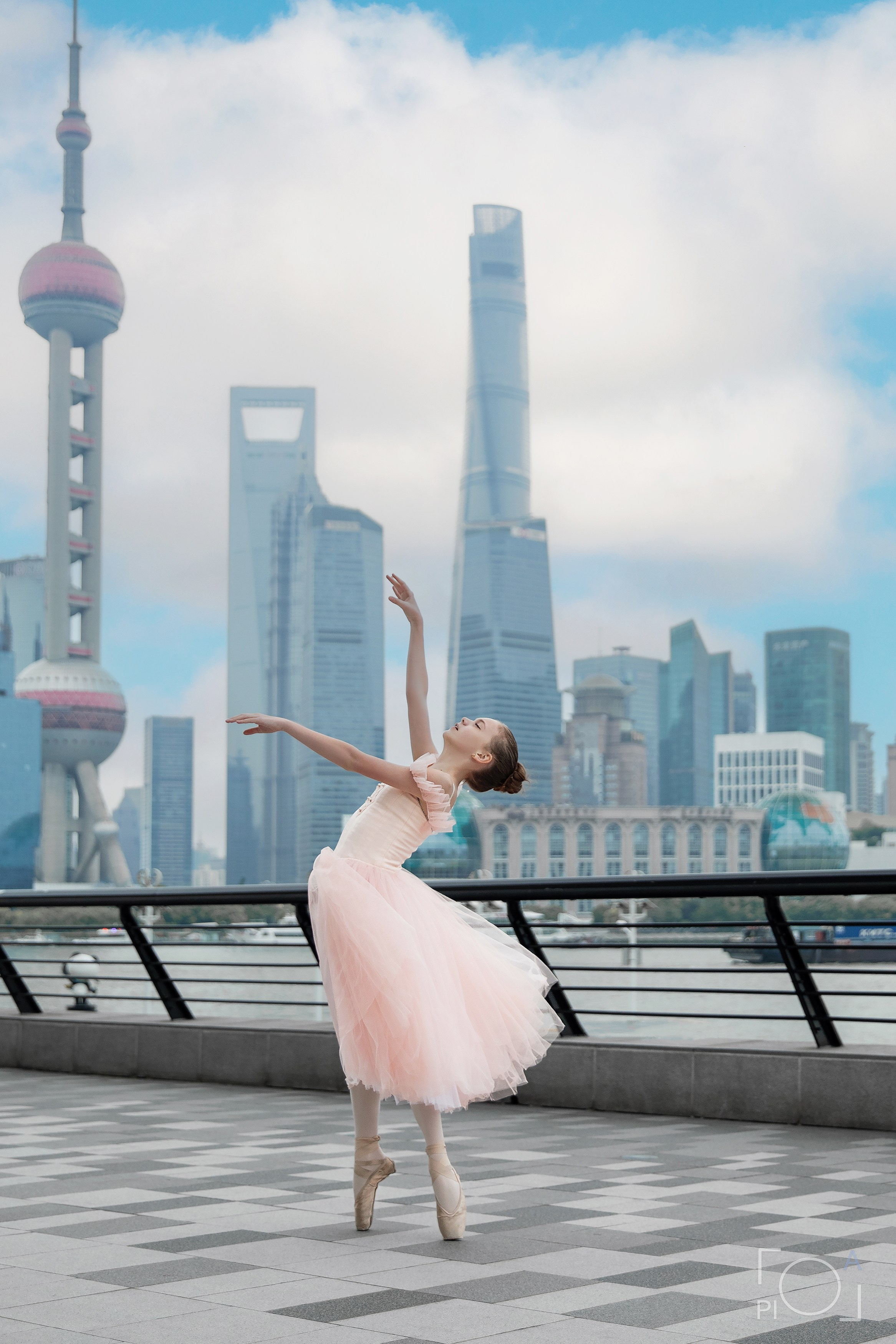 Фотосессия в Шанхае для девочки 11 лет. Маленькая балерина в розовом платье с пышной длинной пачкой, танцует на набережной в Шанхае с видом на Lujiazui