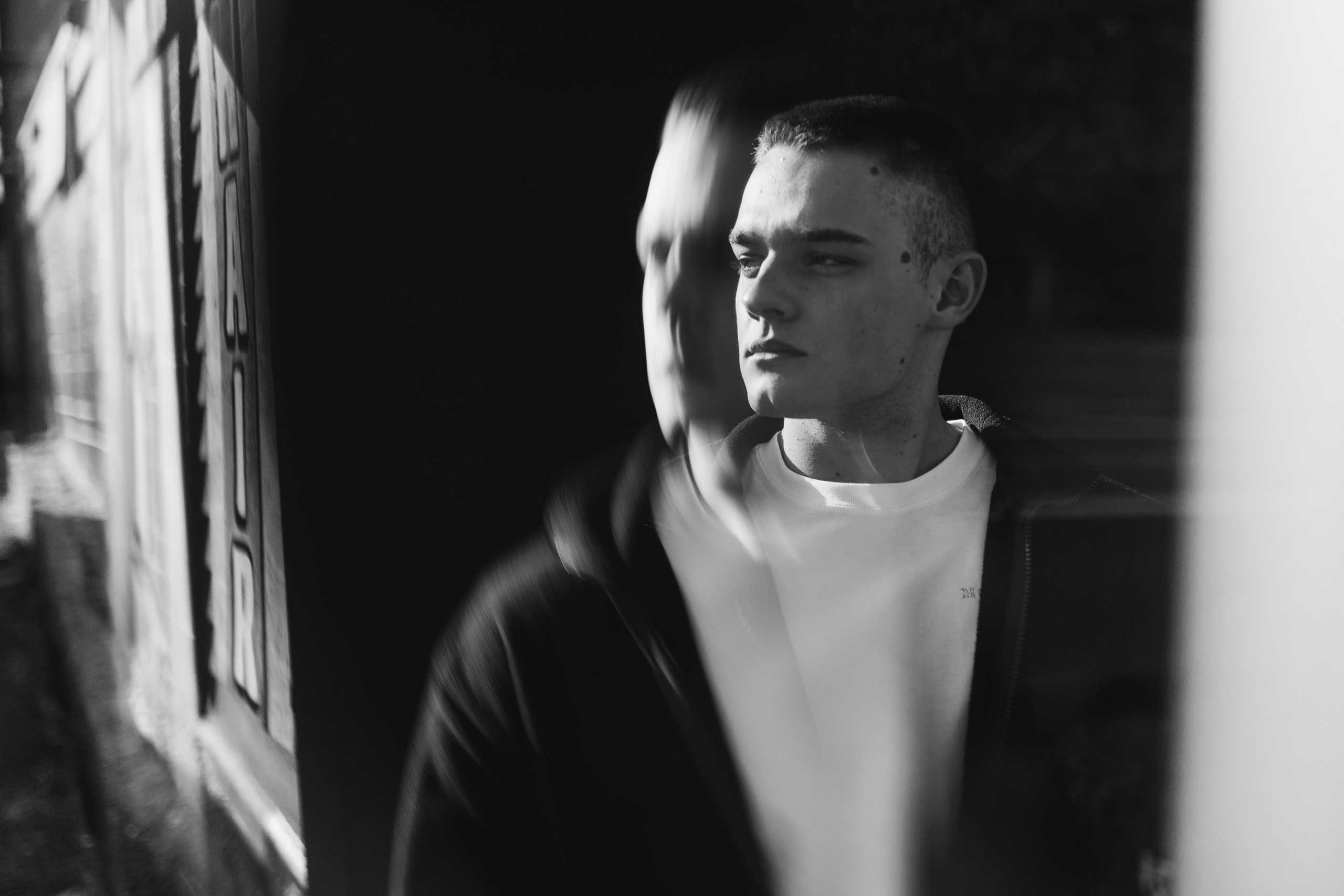 Black-and-white photo of man with suspenders indoors