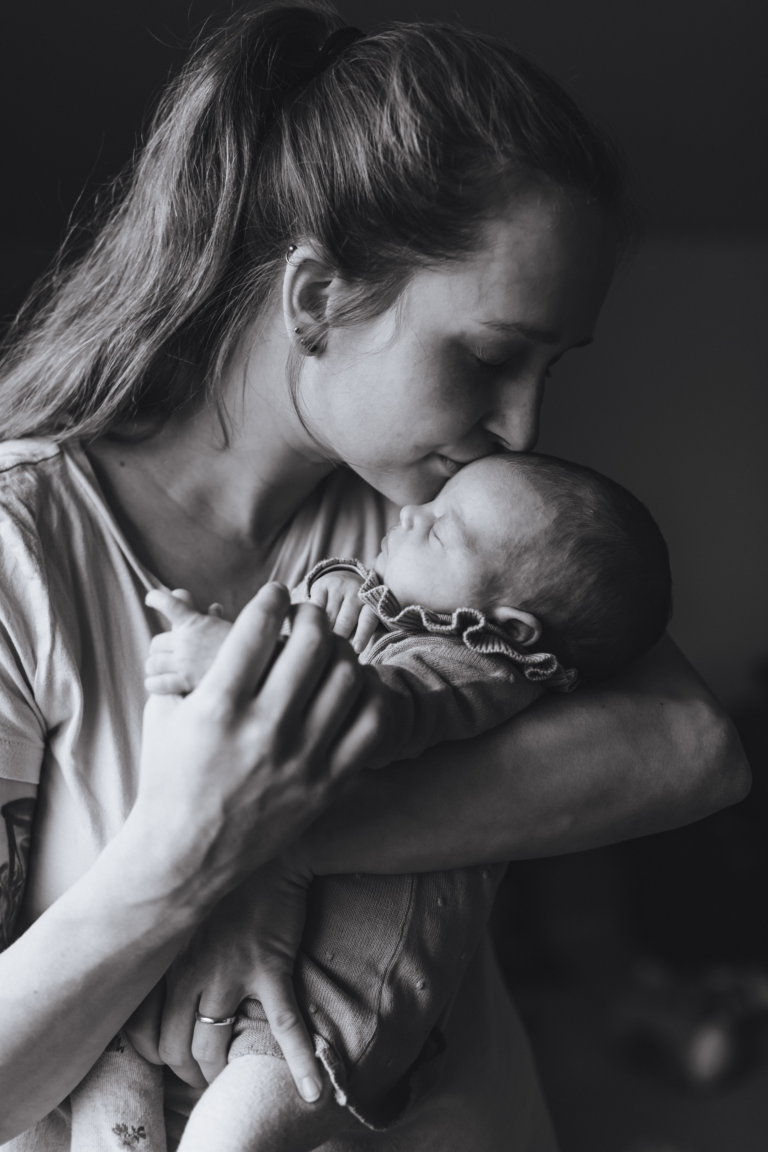 Mama küsst ihr Baby zärtlich auf die Stirn.