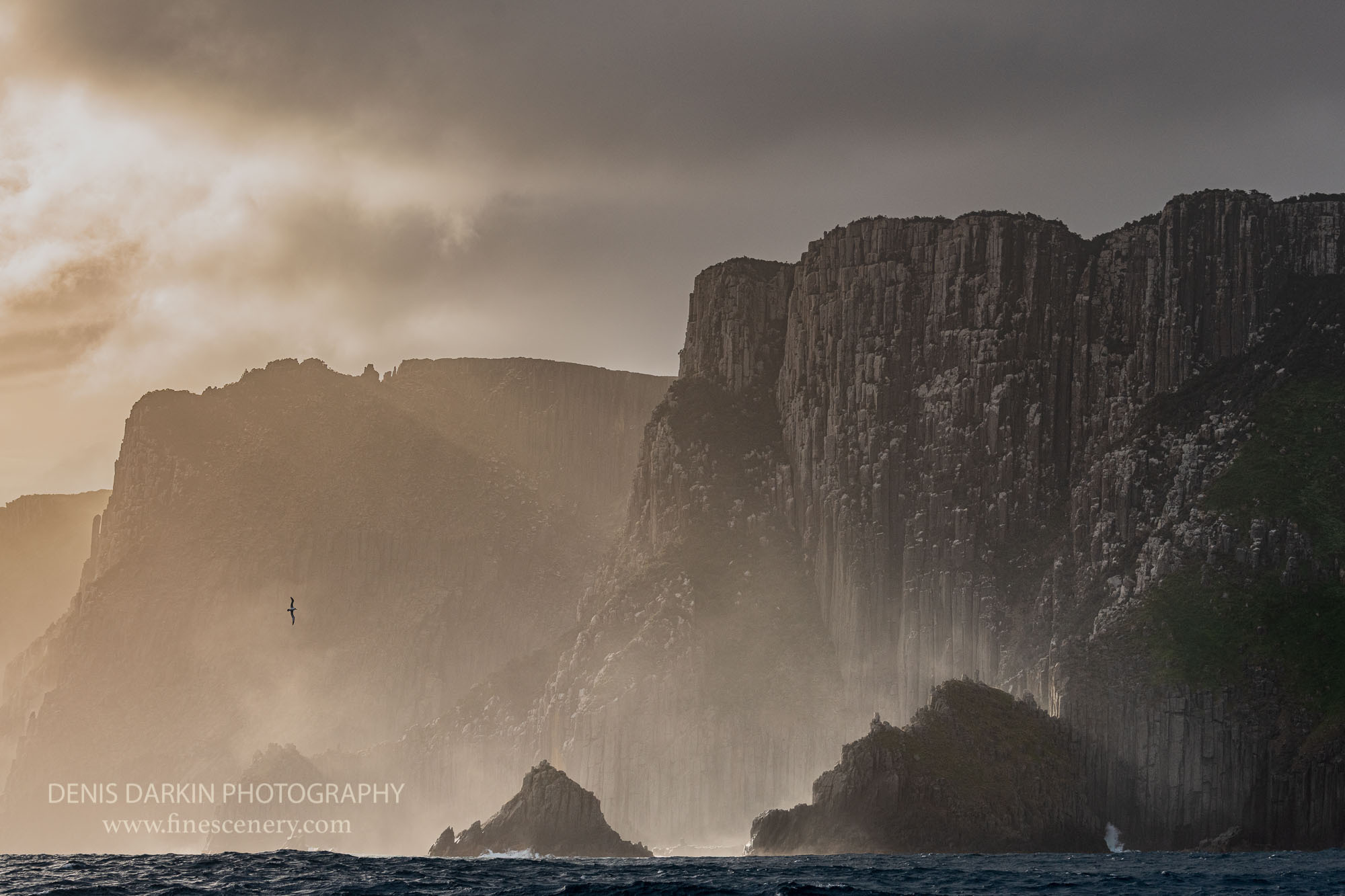 Ocean waves, spray and light at Cape Pillar, Tasmania. The height of these cliffs is over 300 meters, so waves look tiny, but they are not. These are the highest sea cliffs in Southern Hemisphere.