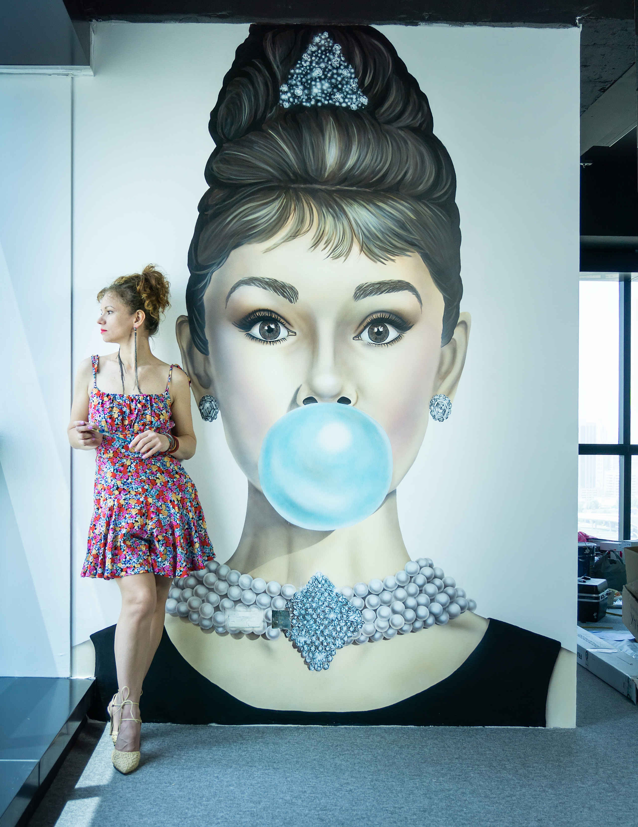 Realistic style wall-painting famous portrait of pretty Audrey Hepburn special for one creative office in Dubai. 2022