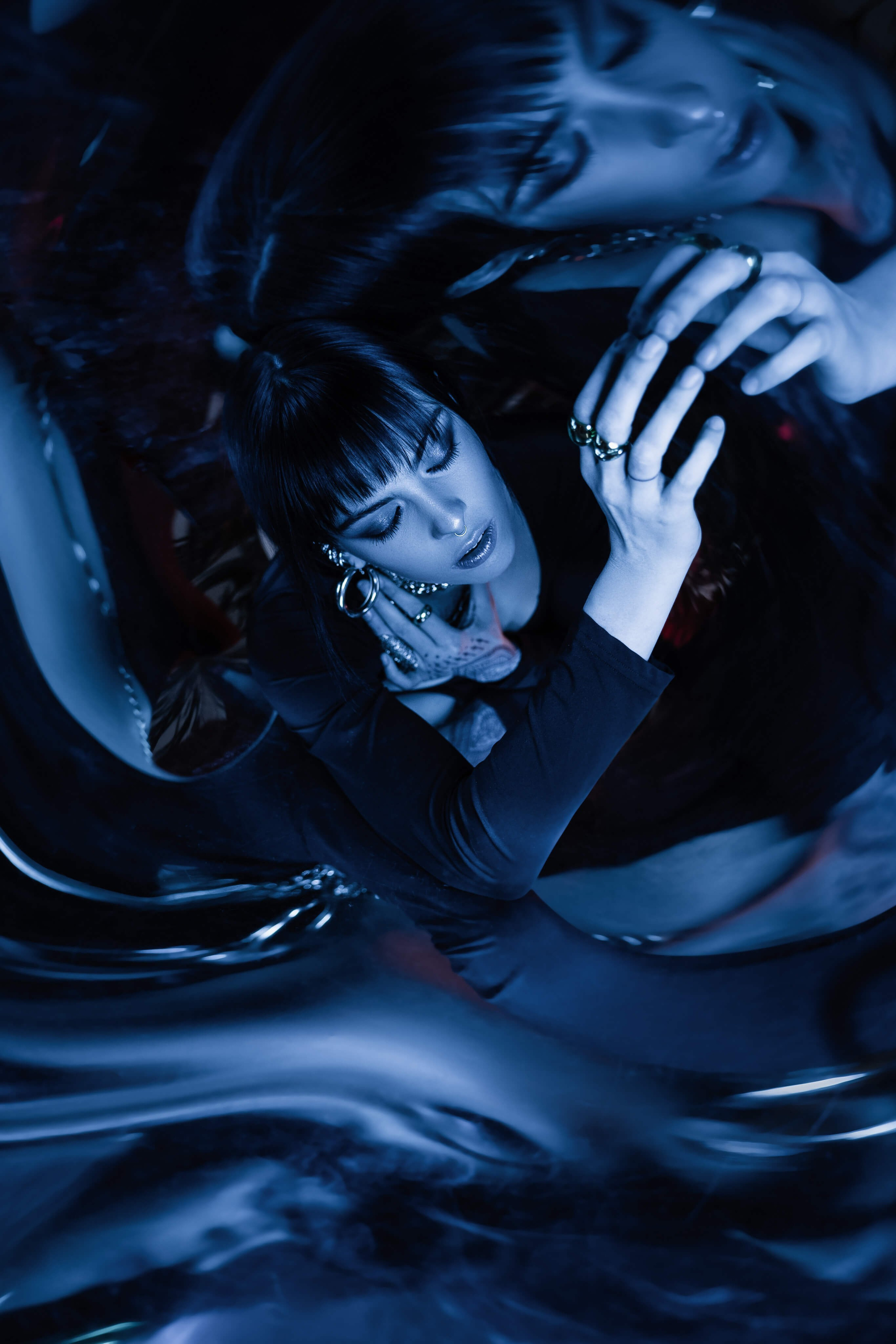 Editorial fashion portrait with motion blur and reflective textures, cinematic blue lighting