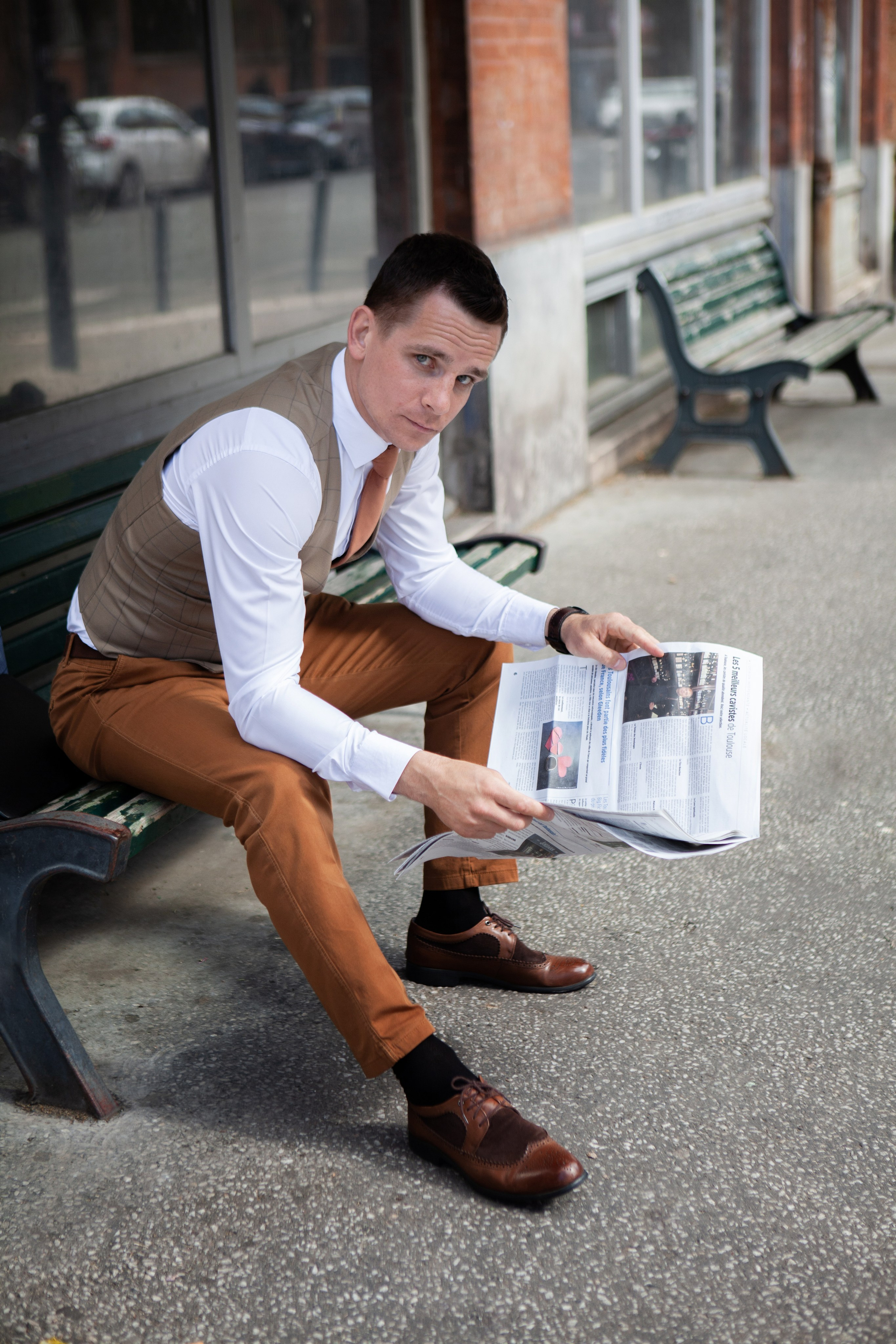 personal branding portrait of a man sitting on a bench holding a newspaper in Toulouse