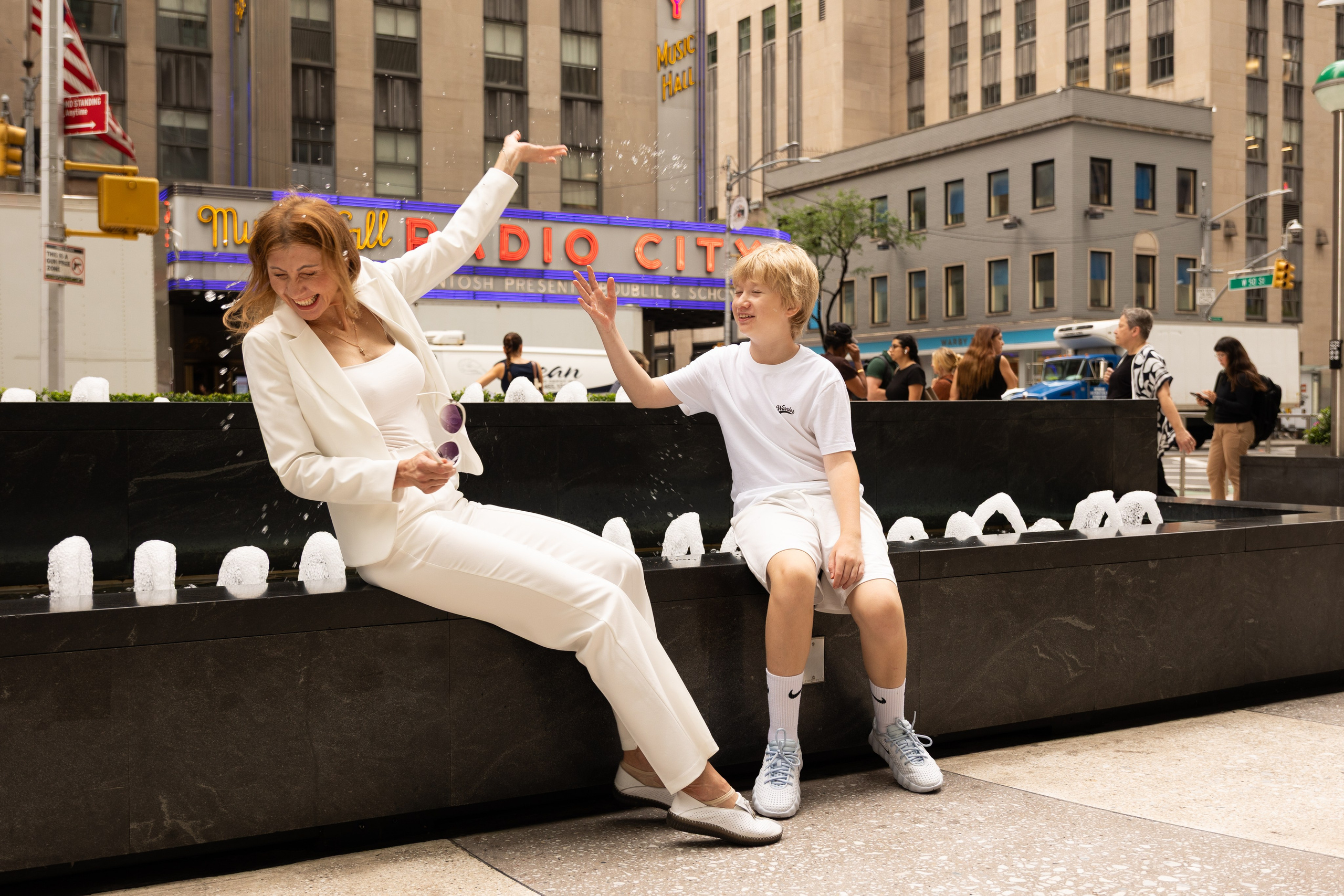 Boy relaxing beside the fountain outside Radio City Music Hall