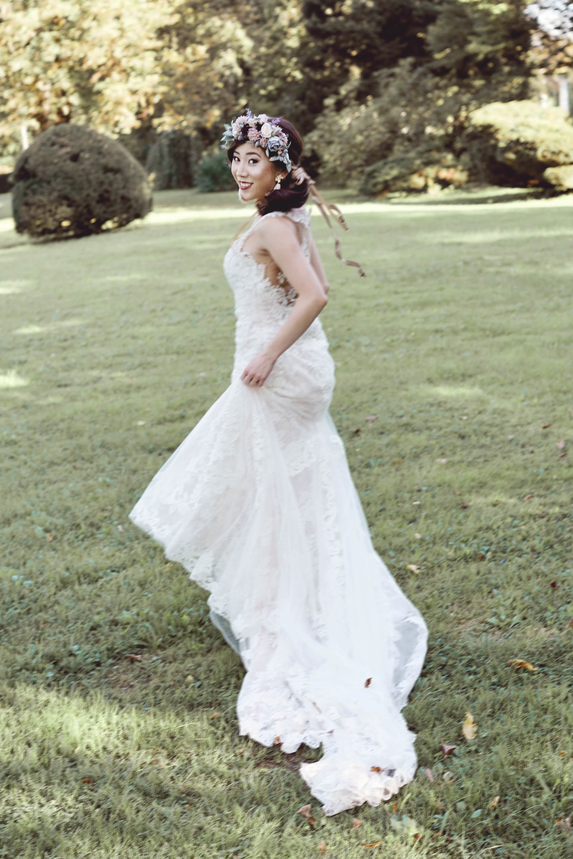 Joyful bride running across historic Vila Bled lawn sunset.