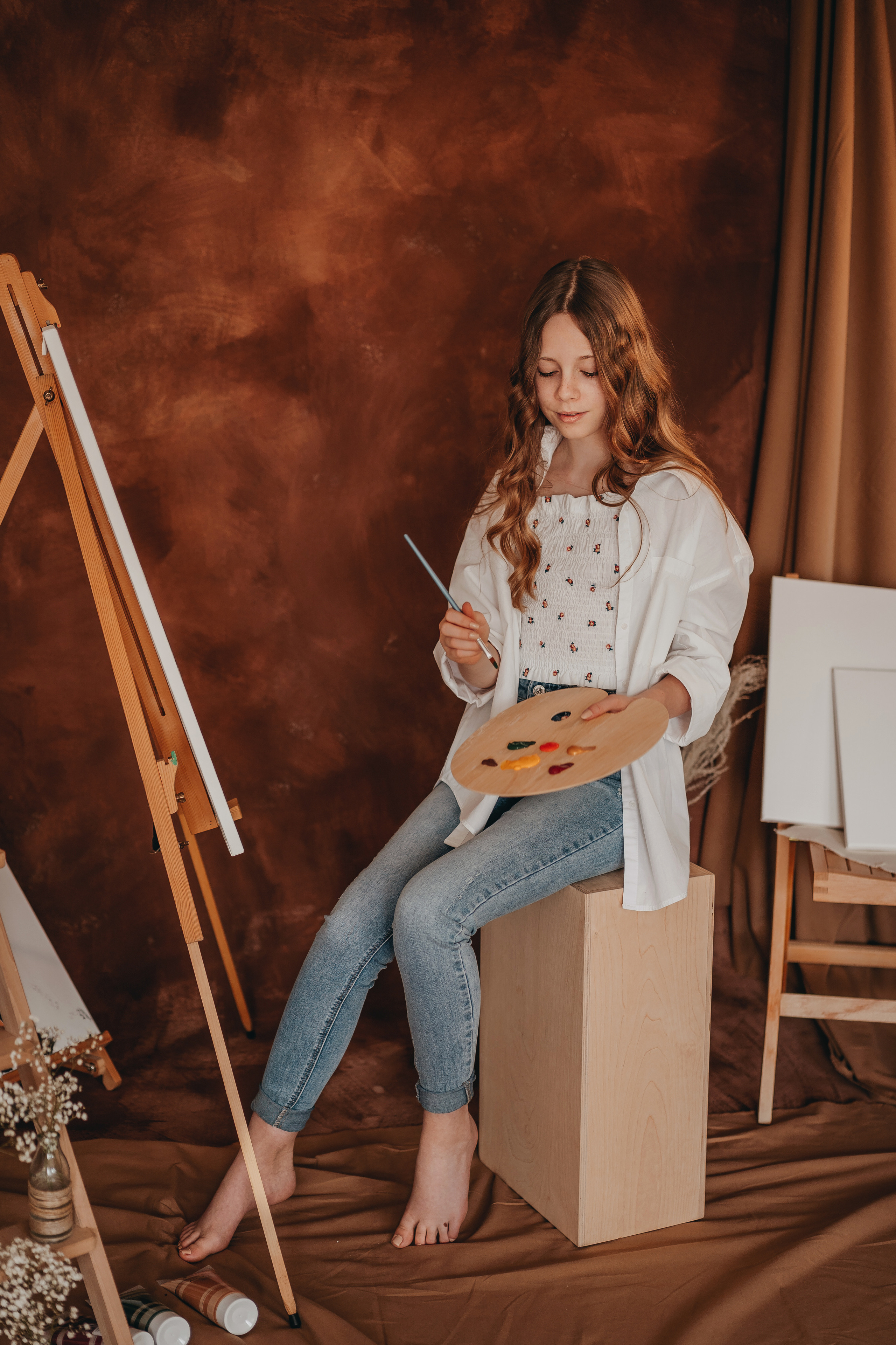 Mädchen beim Malen mit Stafelei und Farben