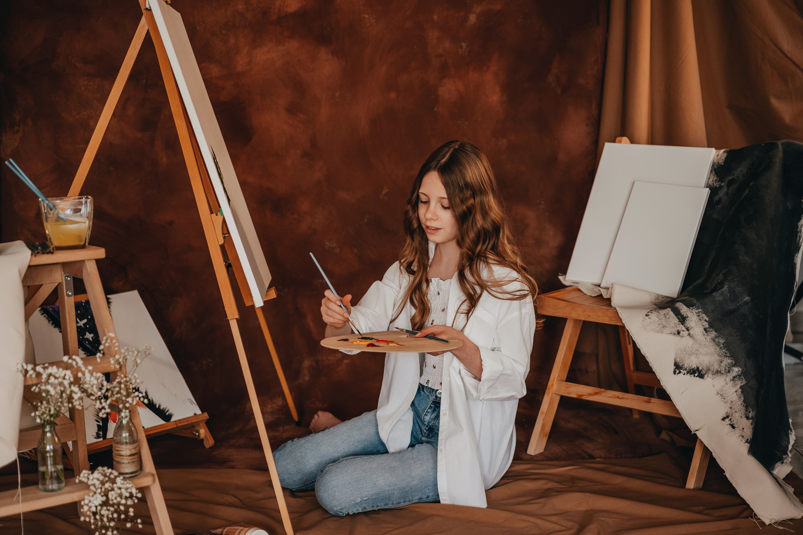 Mädchen beim Malen mit Stafelei und Farben