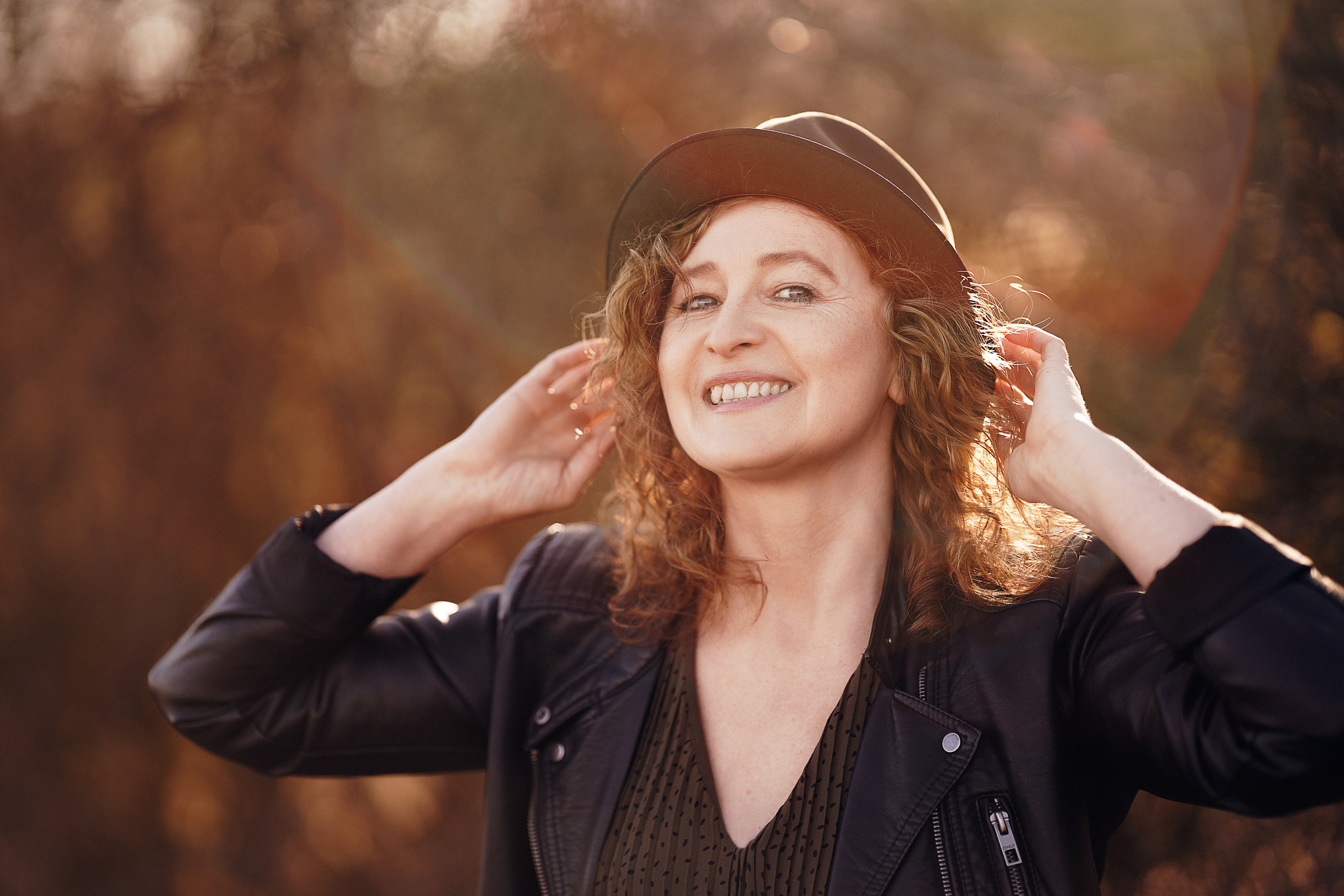 Glückliche Frau mit Hut  im Frühlingslicht