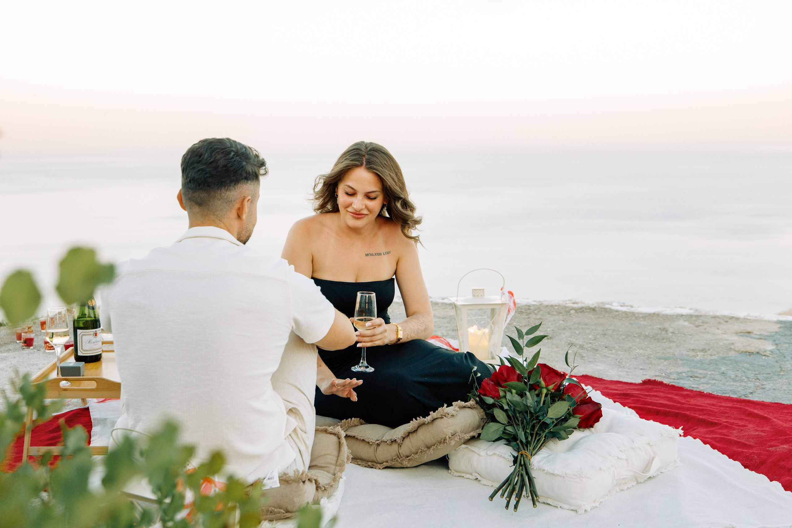 "Liebevoller Blickkontakt: Ein Paar auf dem Felsplateau des Profitis Ilias vor der Kulisse von Faliraki und dem Mittelmeer."