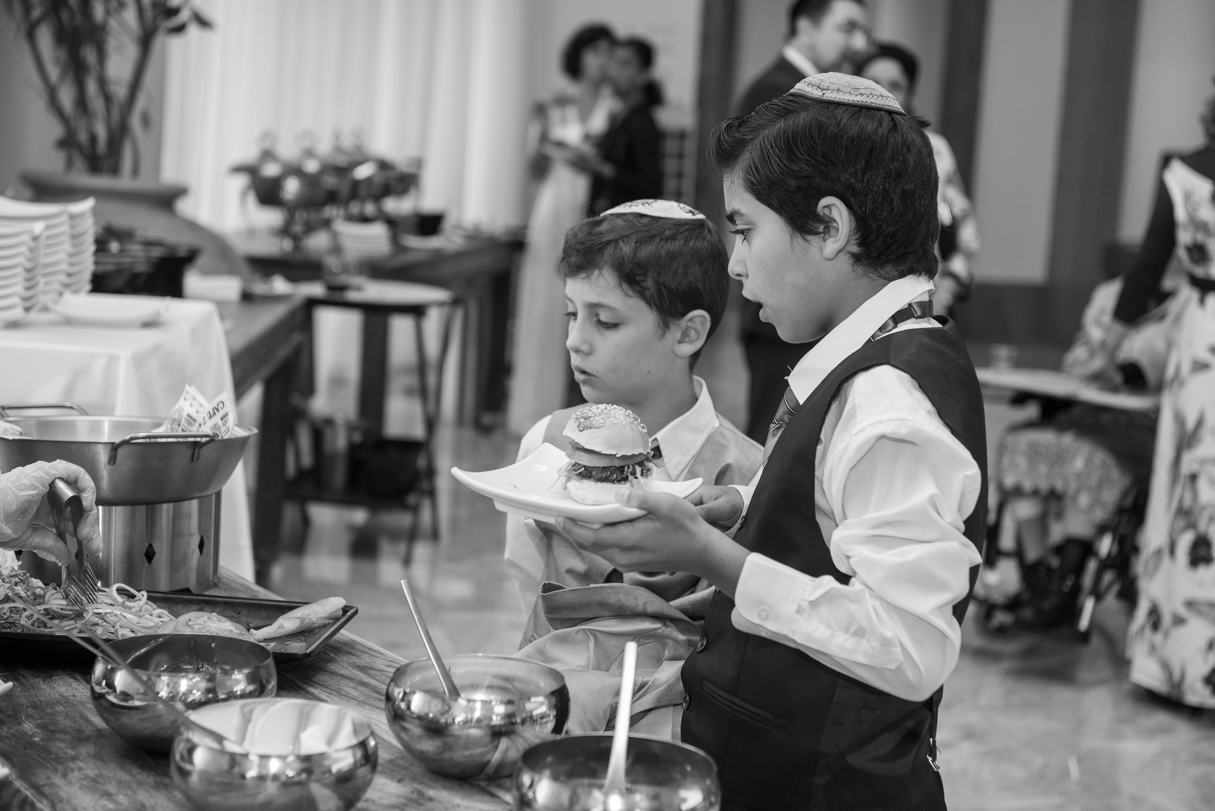 Children in kippahs enjoying food at the reception buffet during Simone and Michael's wedding at the Leonardo Hotel in Haifa, Israel