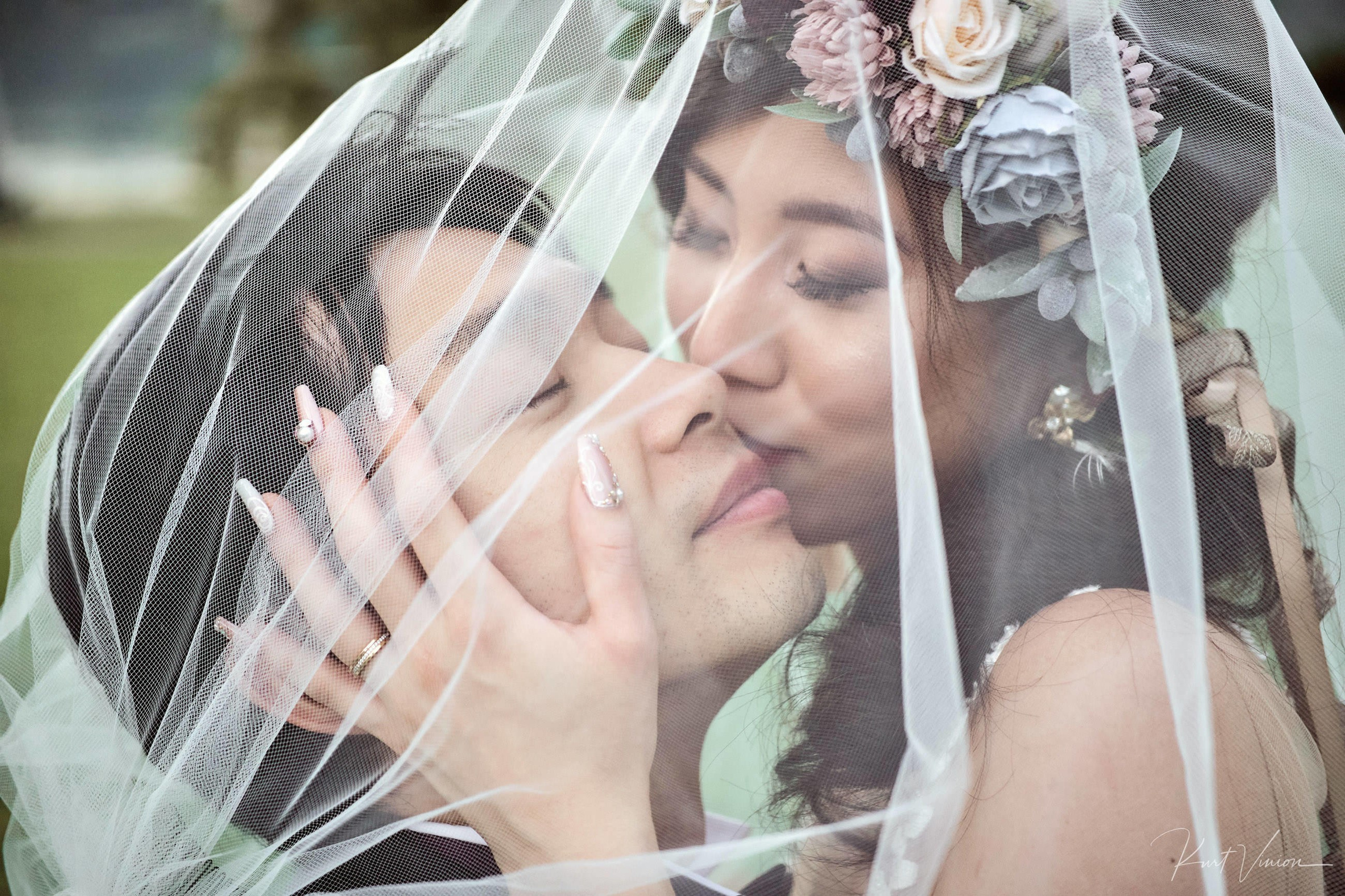 Newlyweds playful intimate embrace under bride's veil Vila Bled.